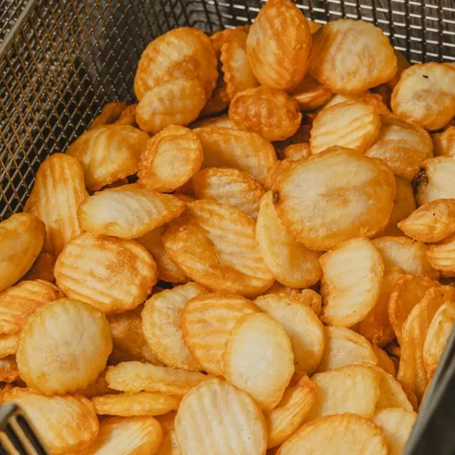 Golden, ridged potato chips in a metal basket.