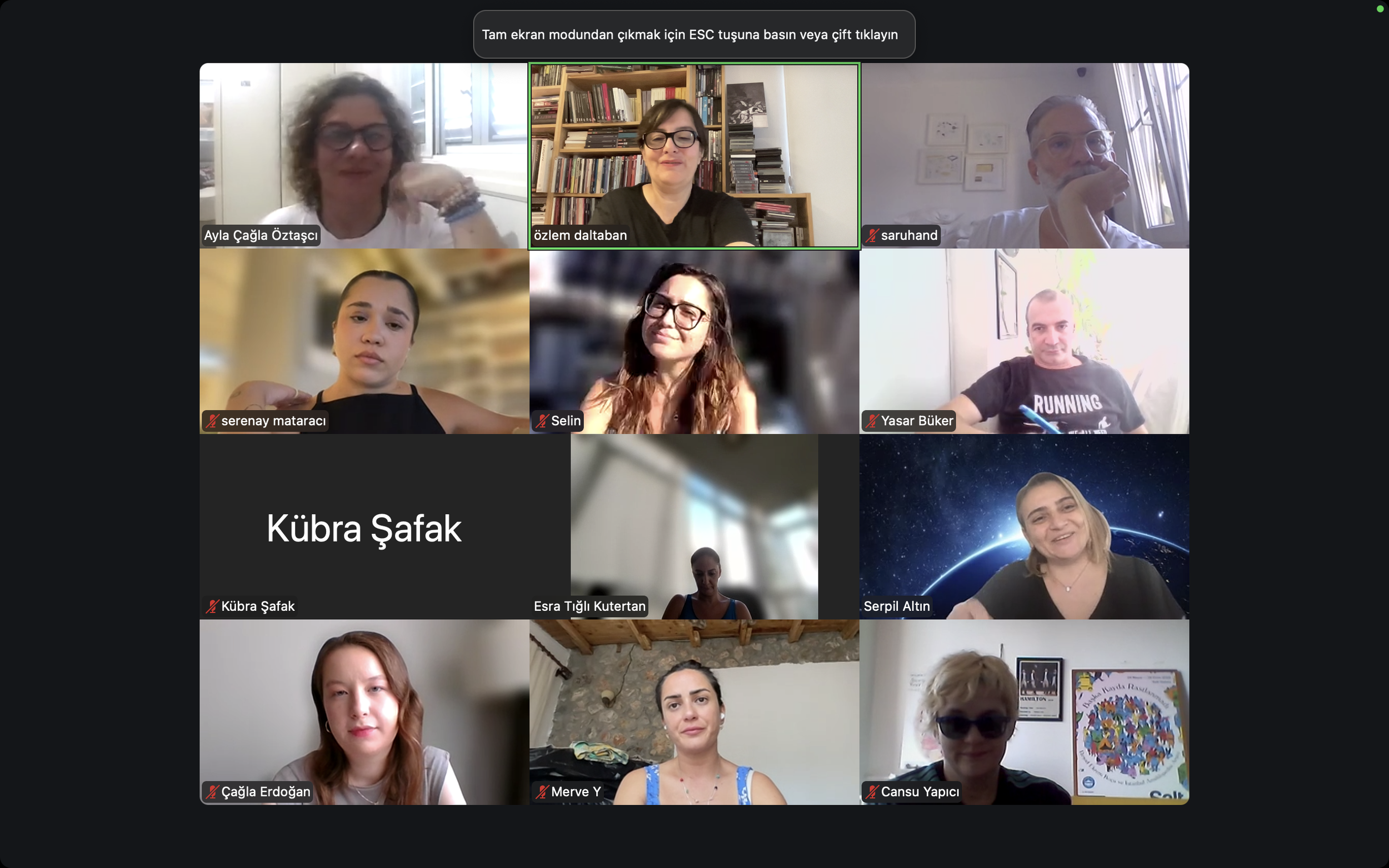 Screenshot of a virtual meeting with multiple participants, some with muted microphones, in various indoor settings.