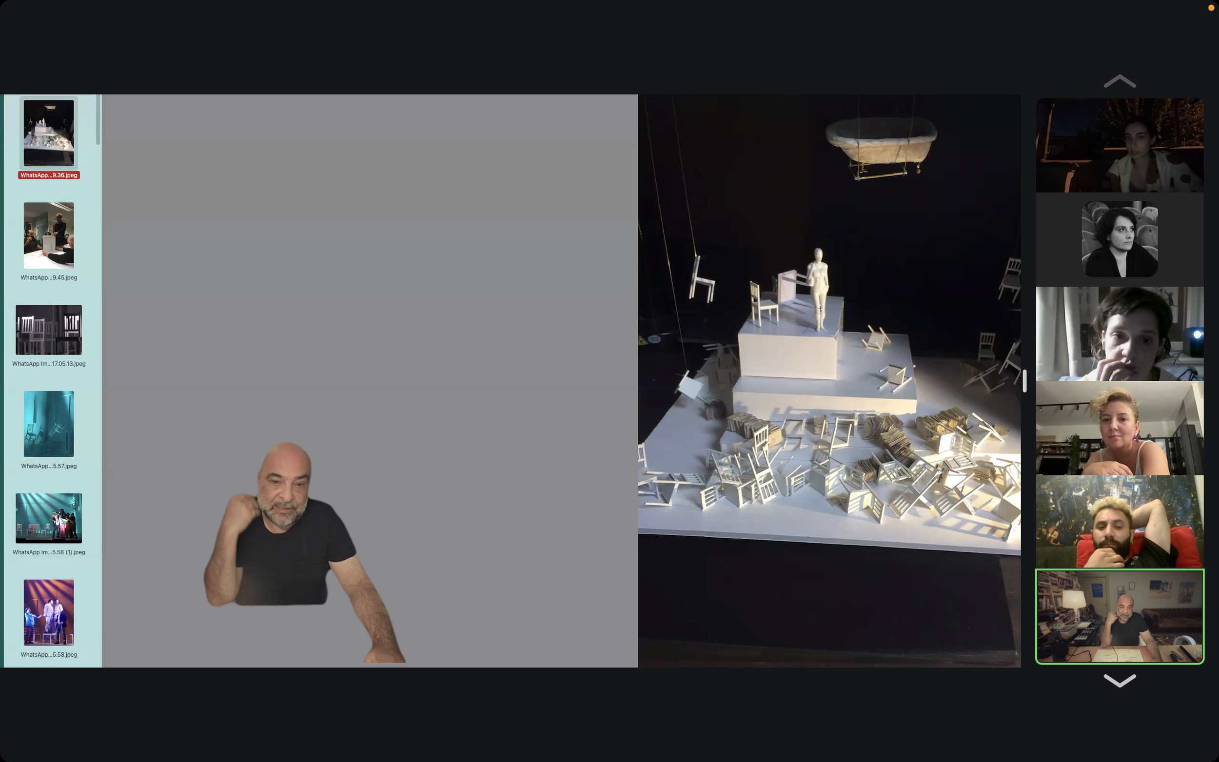A virtual meeting with multiple participants, a large table with model furniture, shoes, and a suspended boat.