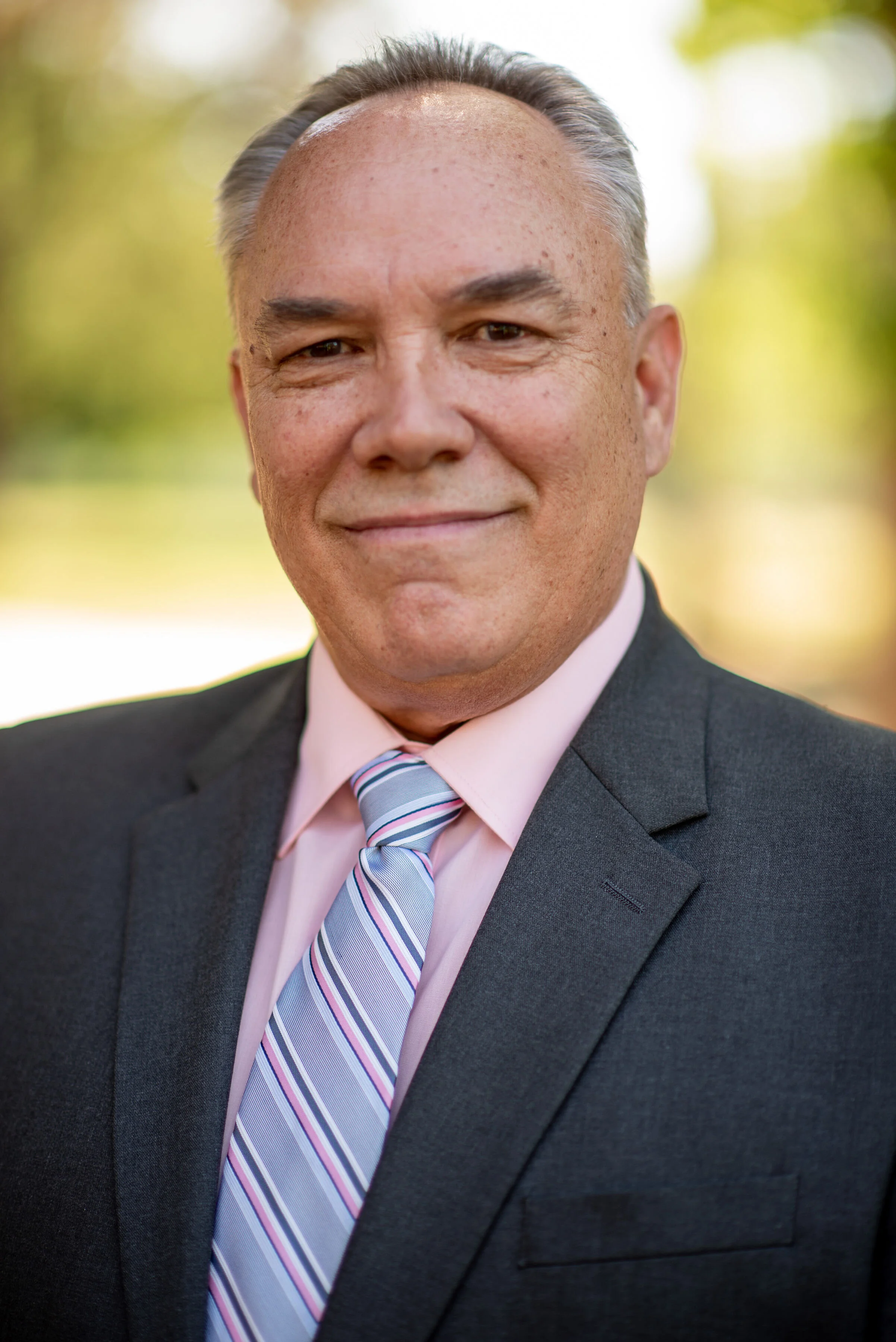 Lyndsi Seth photography- A professional corporate headshot of a smiling man in a suit