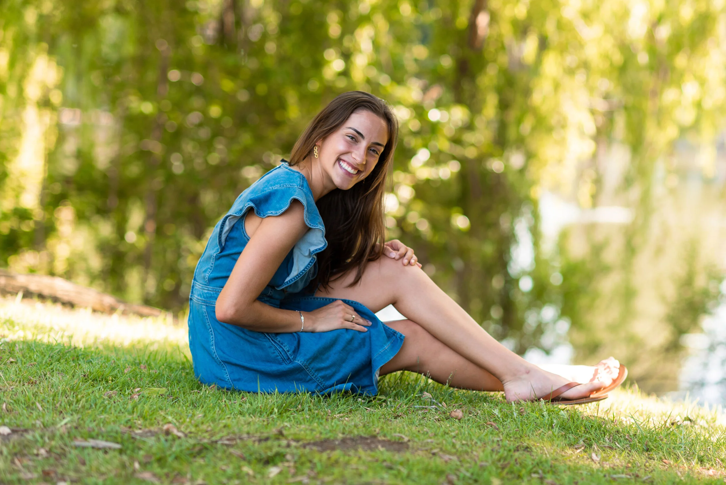 Lyndsi Seth photography- A portrait of a woman smiling and sitting on the grass outdoors