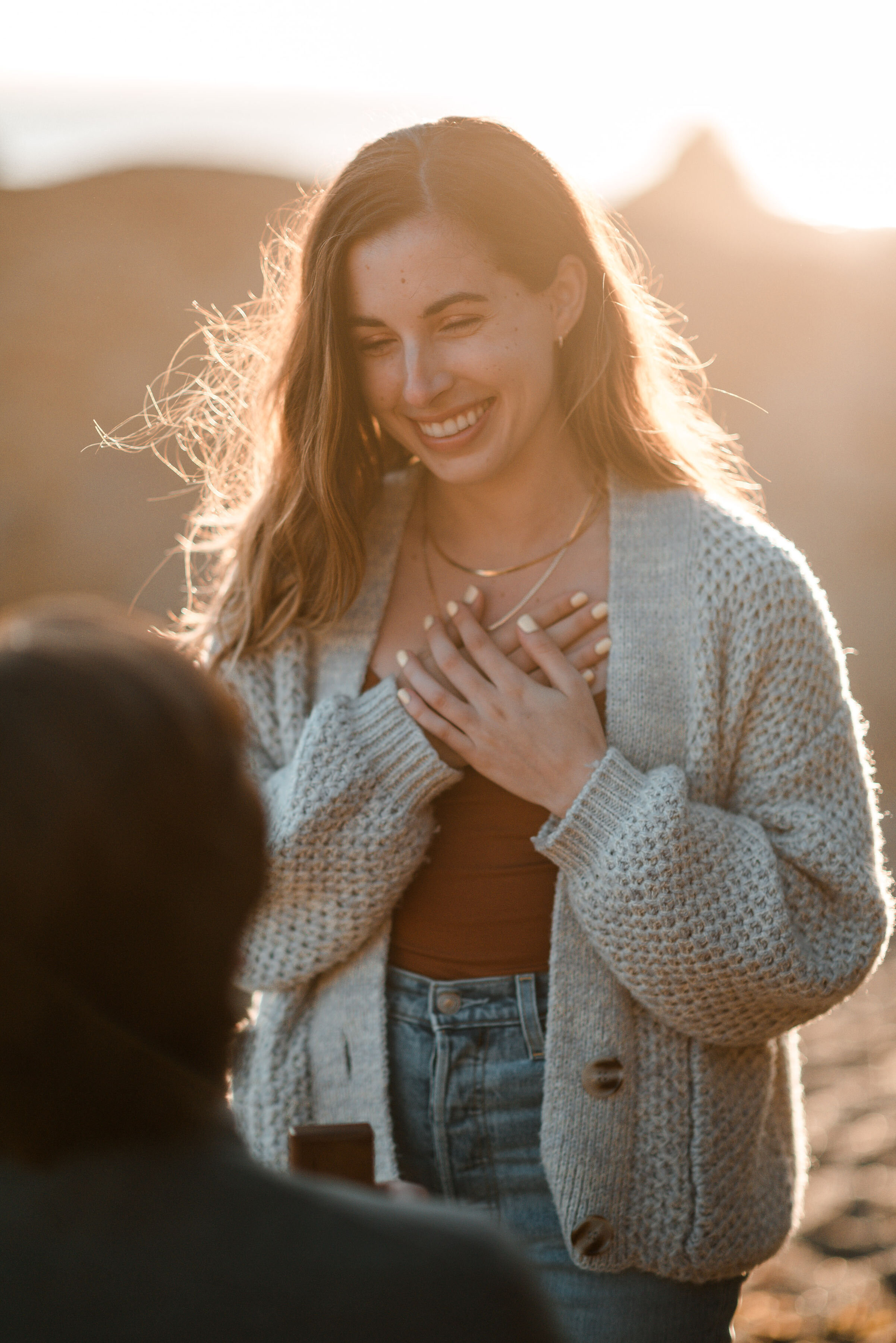 Lyndsi Seth Photography- A close up of a woman smiling with both hands over her heart during a cozy intimate moment
