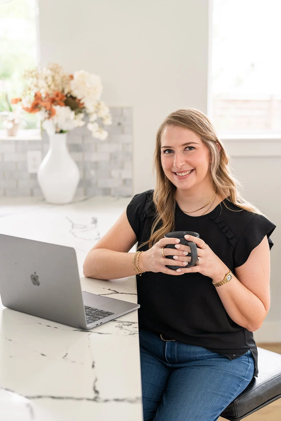 Woman sitting at a computer with a coffee mug.