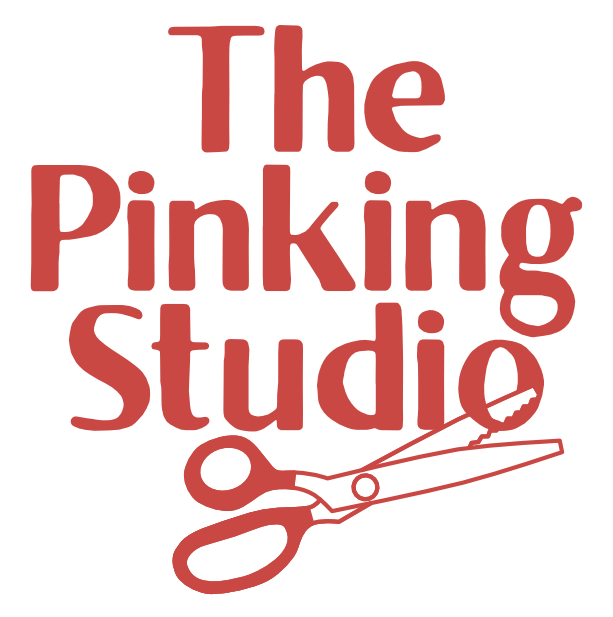 Logo for The Pinking Studio with text and a pair of scissors