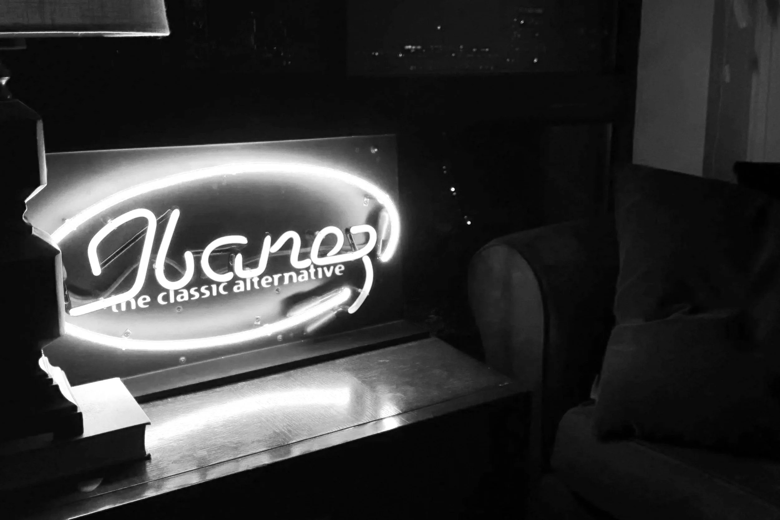 A lit neon sign that reads "Vegan" with the subtitle "the classic alternative" is displayed on a counter, with dark surroundings. Nashville Guitar Lessons Zoom Guitar Lessons Virtual Lessons In Person Guitar Lessons Session Work Audition Prep