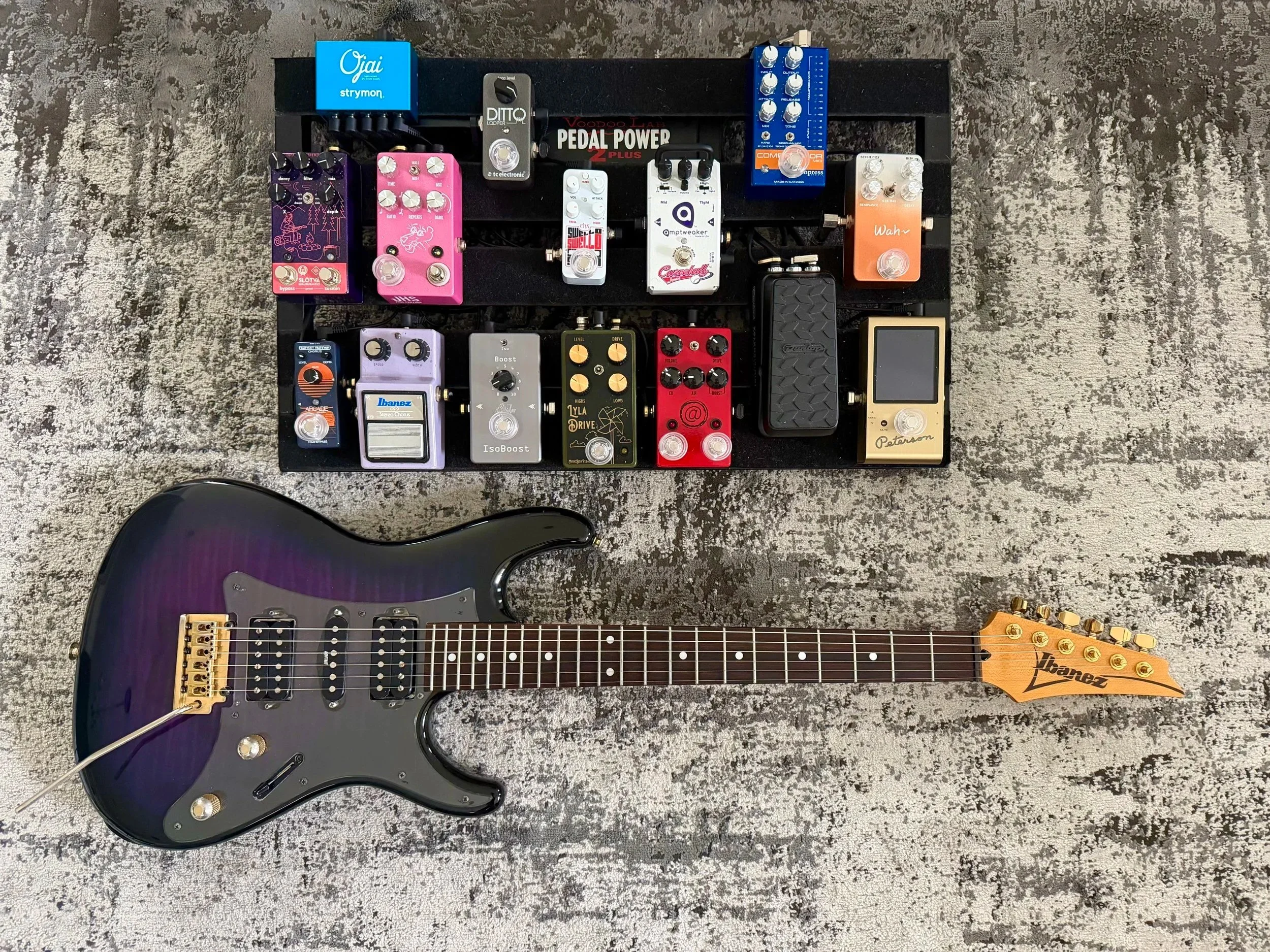 Top view of a guitar effects pedalboard with various colorful pedals and an electric guitar at the bottom.  Nashville Guitar Lessons Zoom Guitar Lessons Virtual Lessons In Person Guitar Lessons Session Work Audition Prep