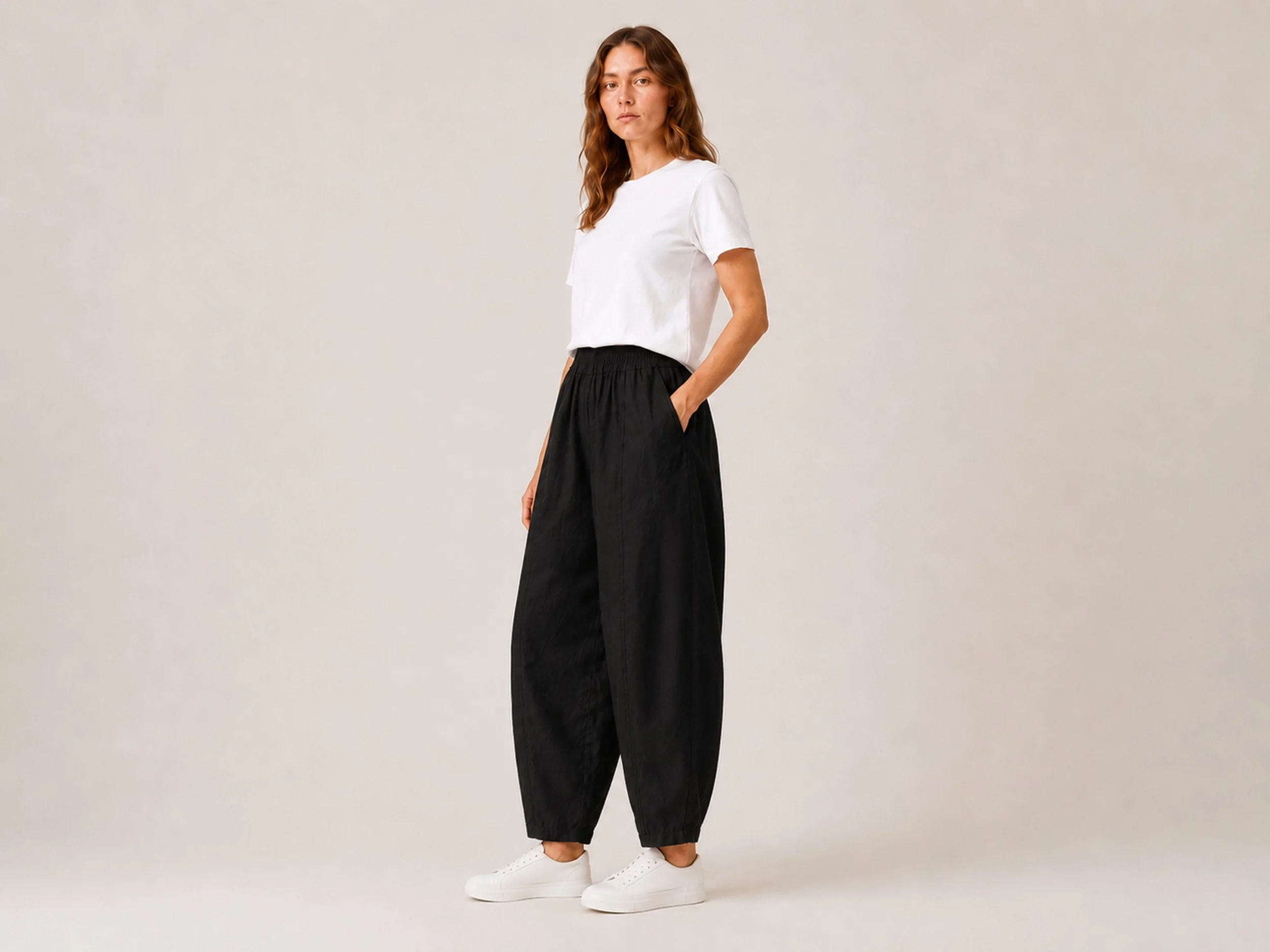 Angled side view of The Flax Studio black Sculpted Cotton Pant, showing the relaxed fit and side pocket.