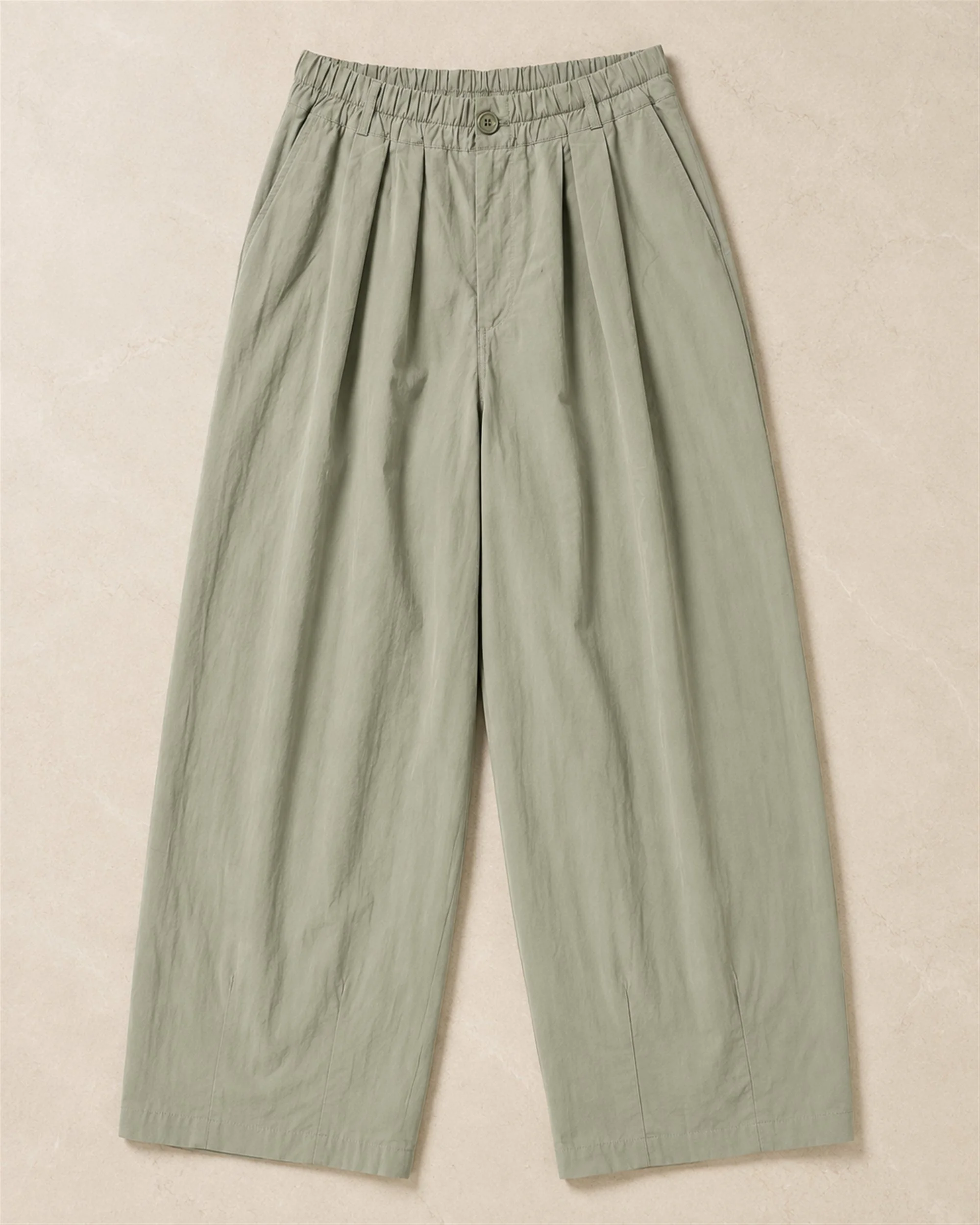 The Flax Studio khaki Button Front Crepe Pant laid flat, showing the gathered waistband and relaxed curved legs.