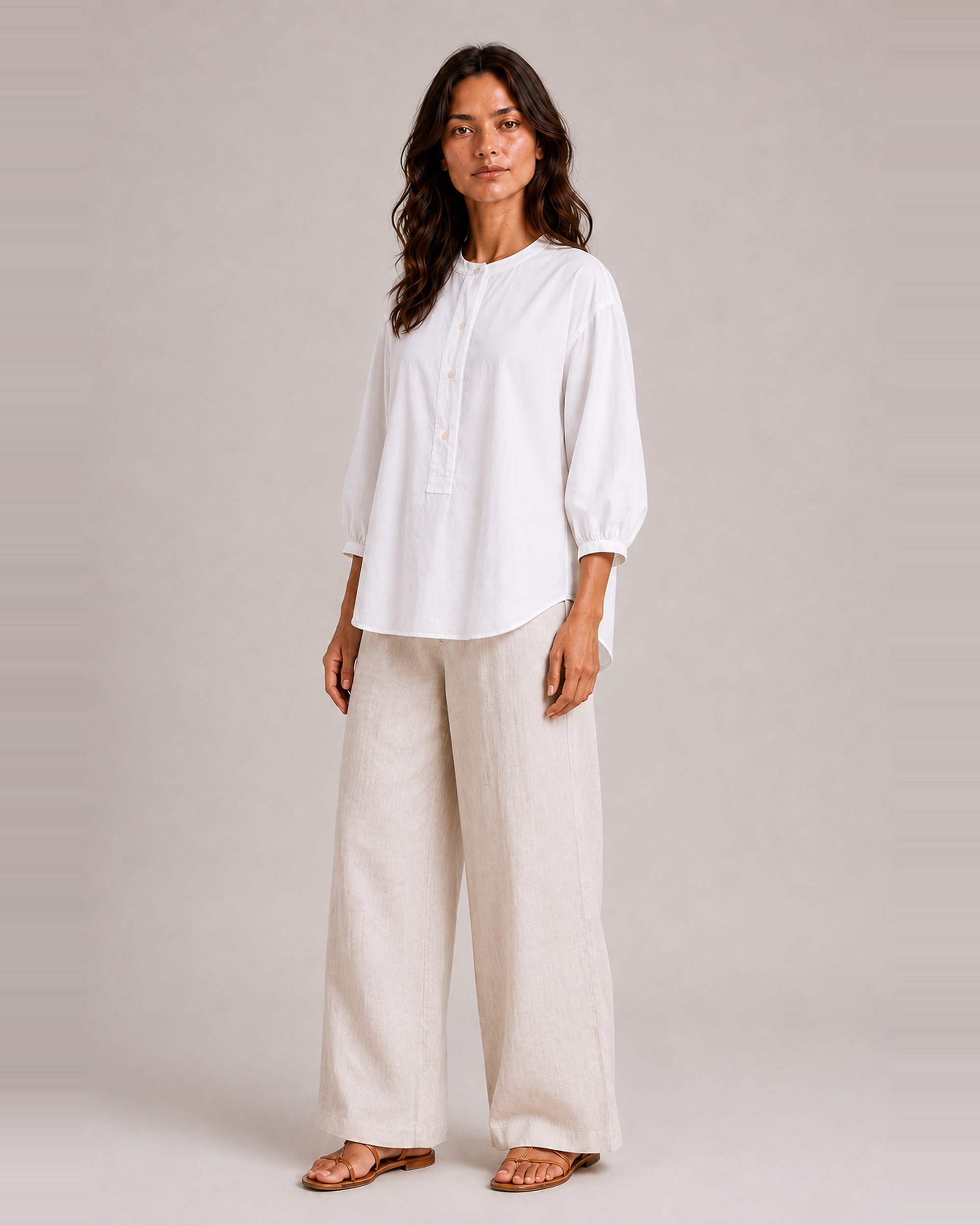 Three-quarter view of The Flax Studio white Voluminous Cotton Top, showing its loose fit and softly curved hem.