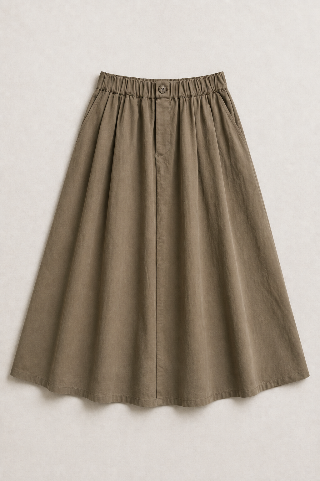 The Flax Studio khaki Button Front Skirt laid flat, showing its gathered elasticated waist and A-line shape.