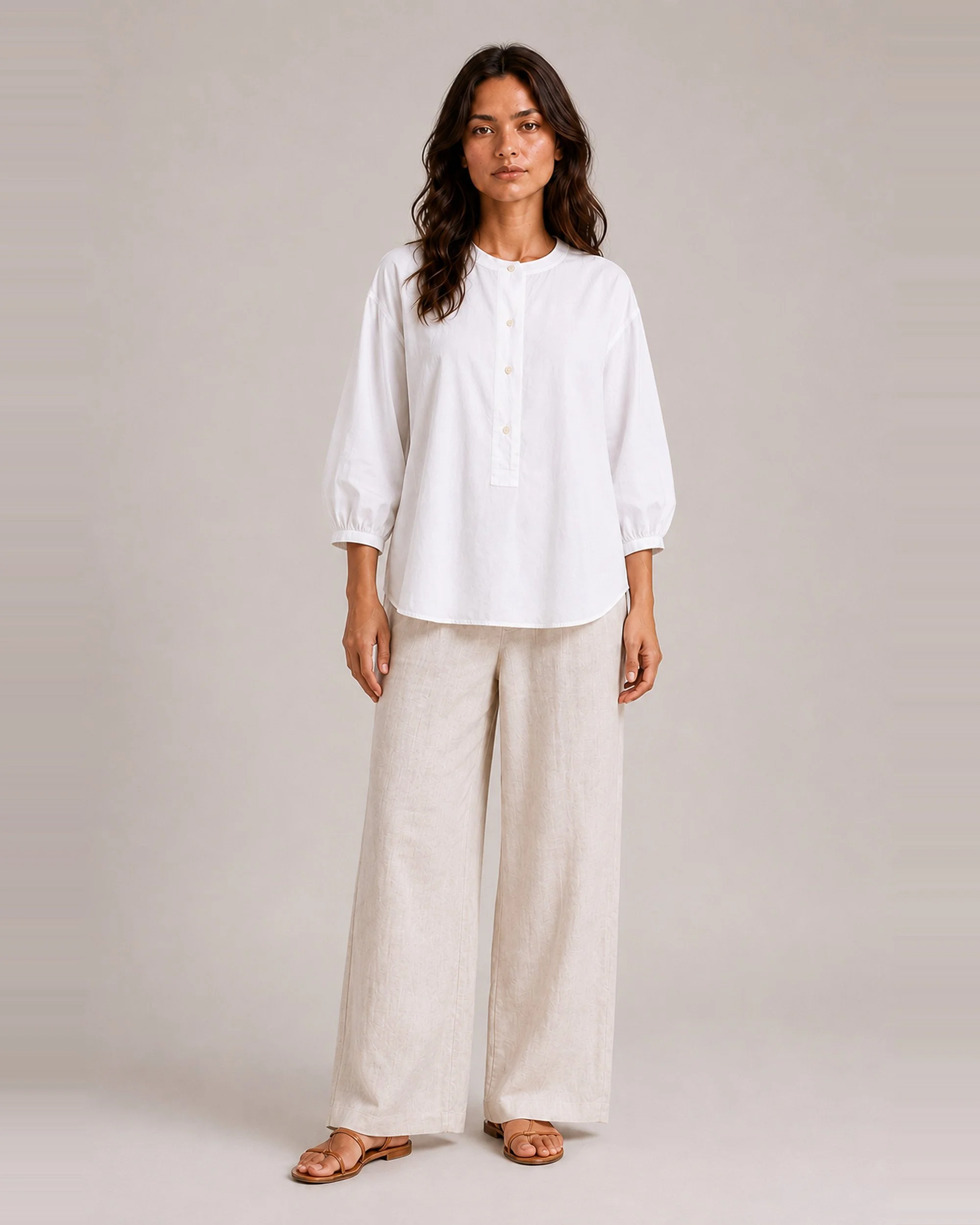 The Flax Studio white Voluminous Cotton Top styled with beige trousers, showing its relaxed shape and gathered sleeves.