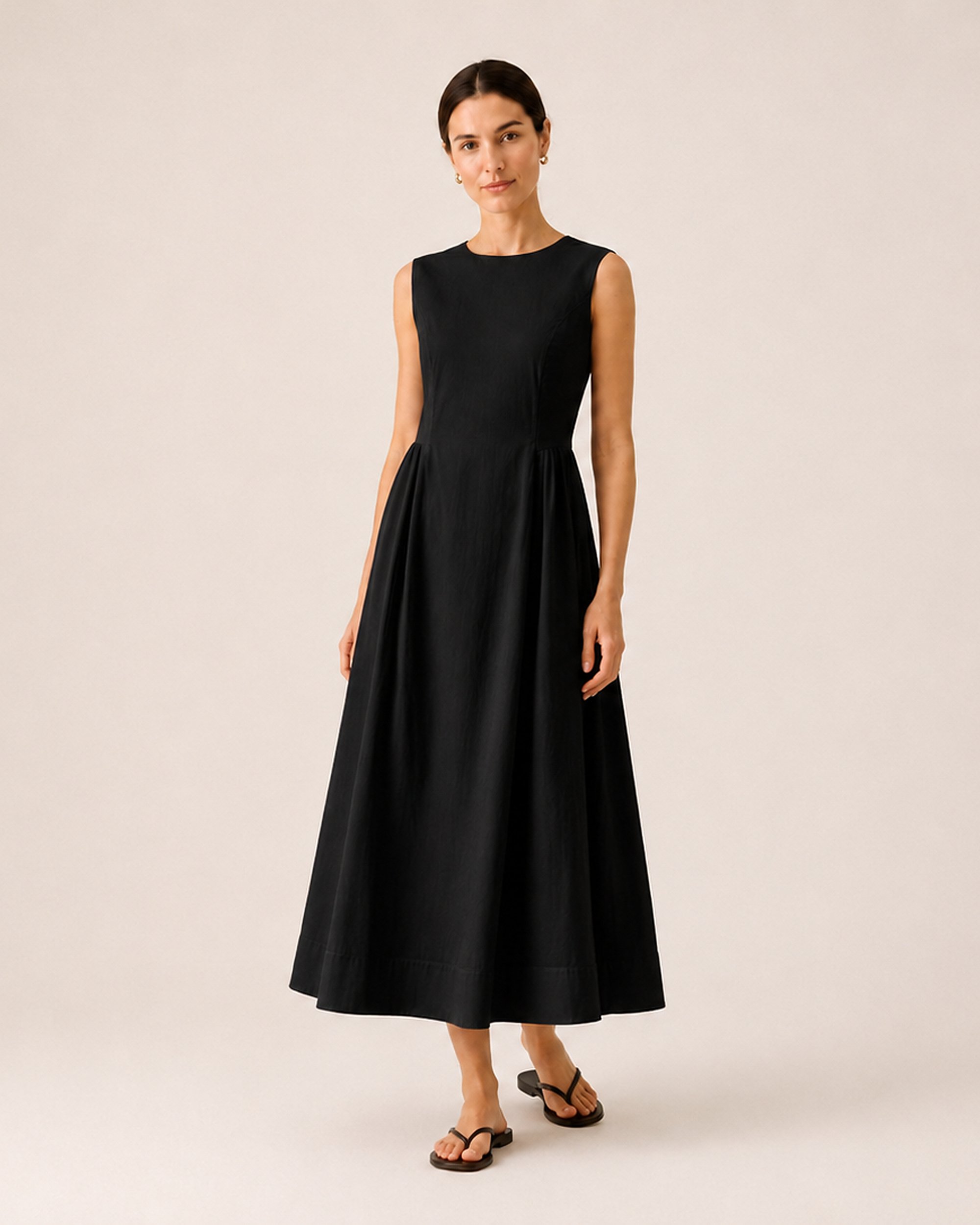The Flax Studio Tailored Dress in black, showing the alternative colour and sleeveless A-line silhouette.