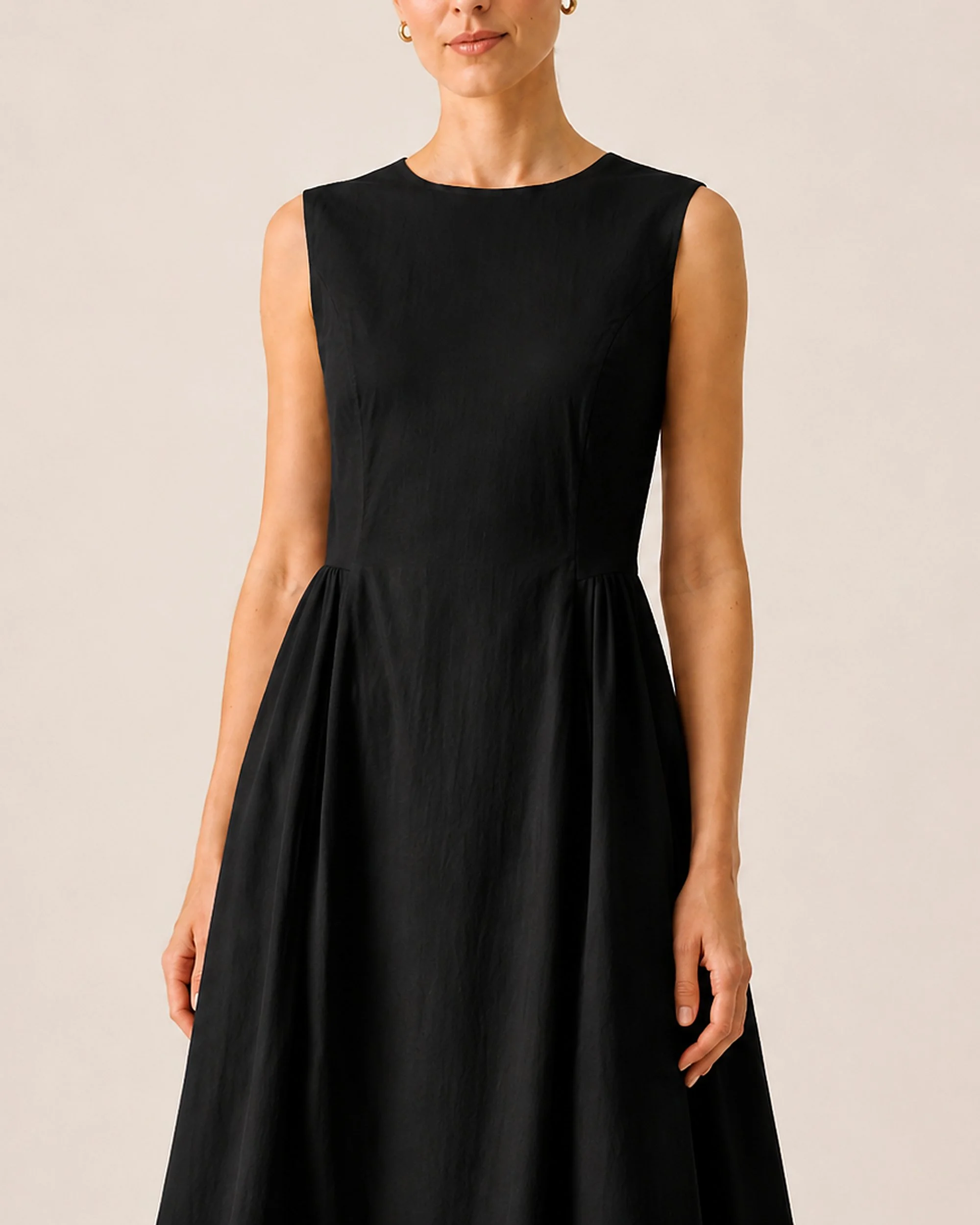 Close-up of The Flax Studio black Tailored Dress, showing the round neckline and waist shaping.