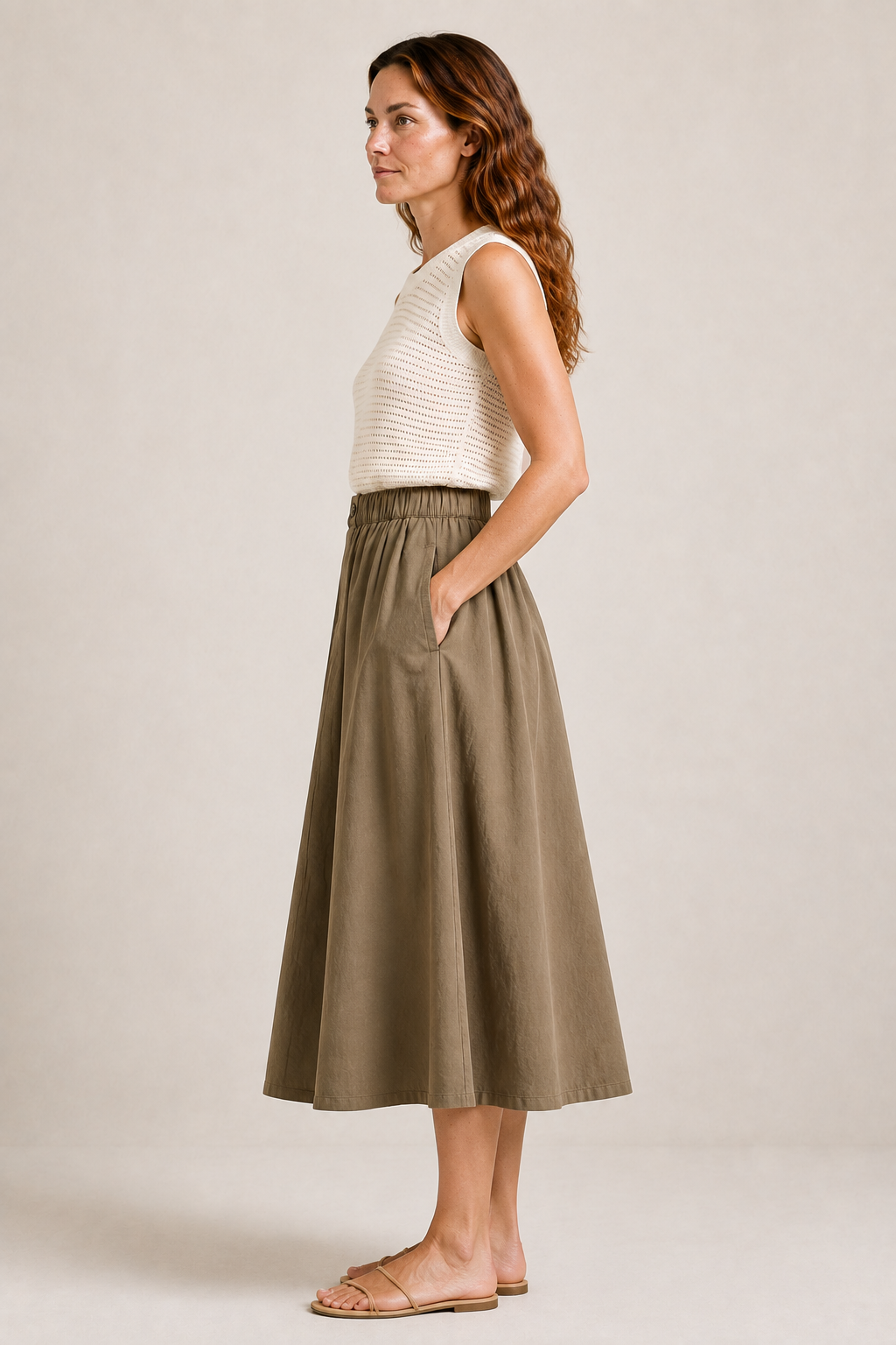 Side view of The Flax Studio khaki Button Front Skirt, showing its side pocket and A-line midi shape.