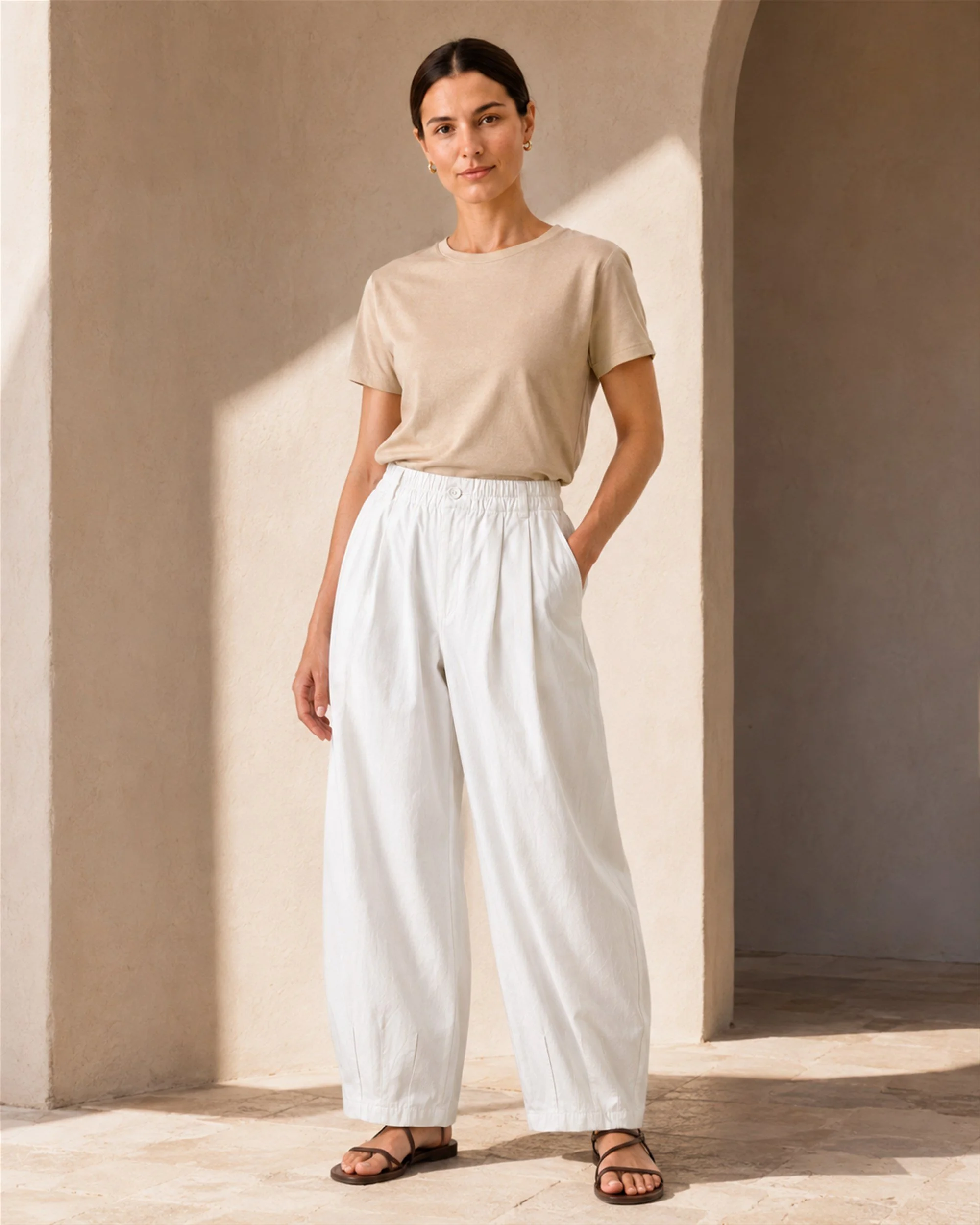 The Flax Studio white Button Front Crepe Pant styled with a beige T-shirt, showing its relaxed barrel-leg silhouette.
