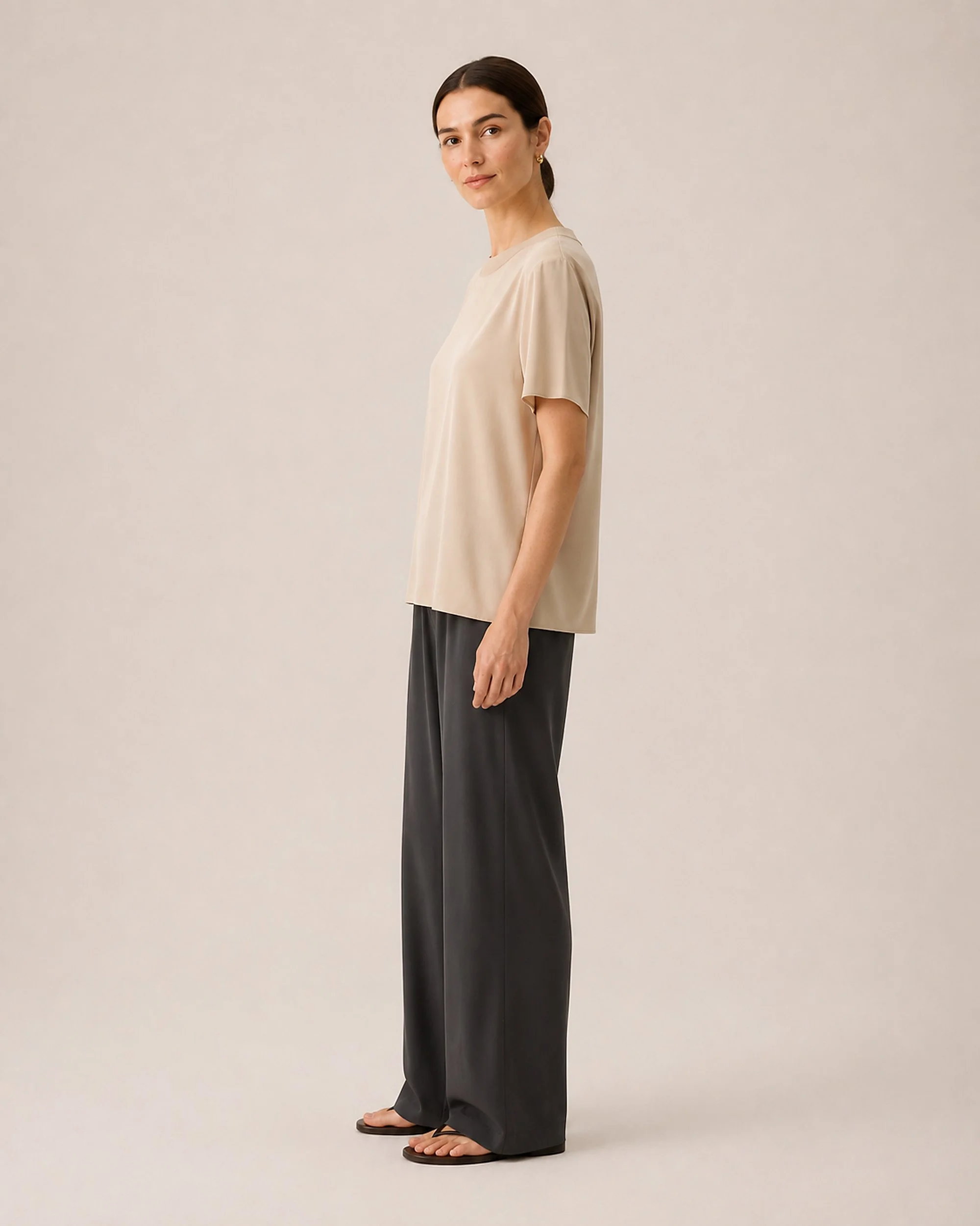 Side view of The Flax Studio beige Silk Crew Neck Top, showing the relaxed silk drape.