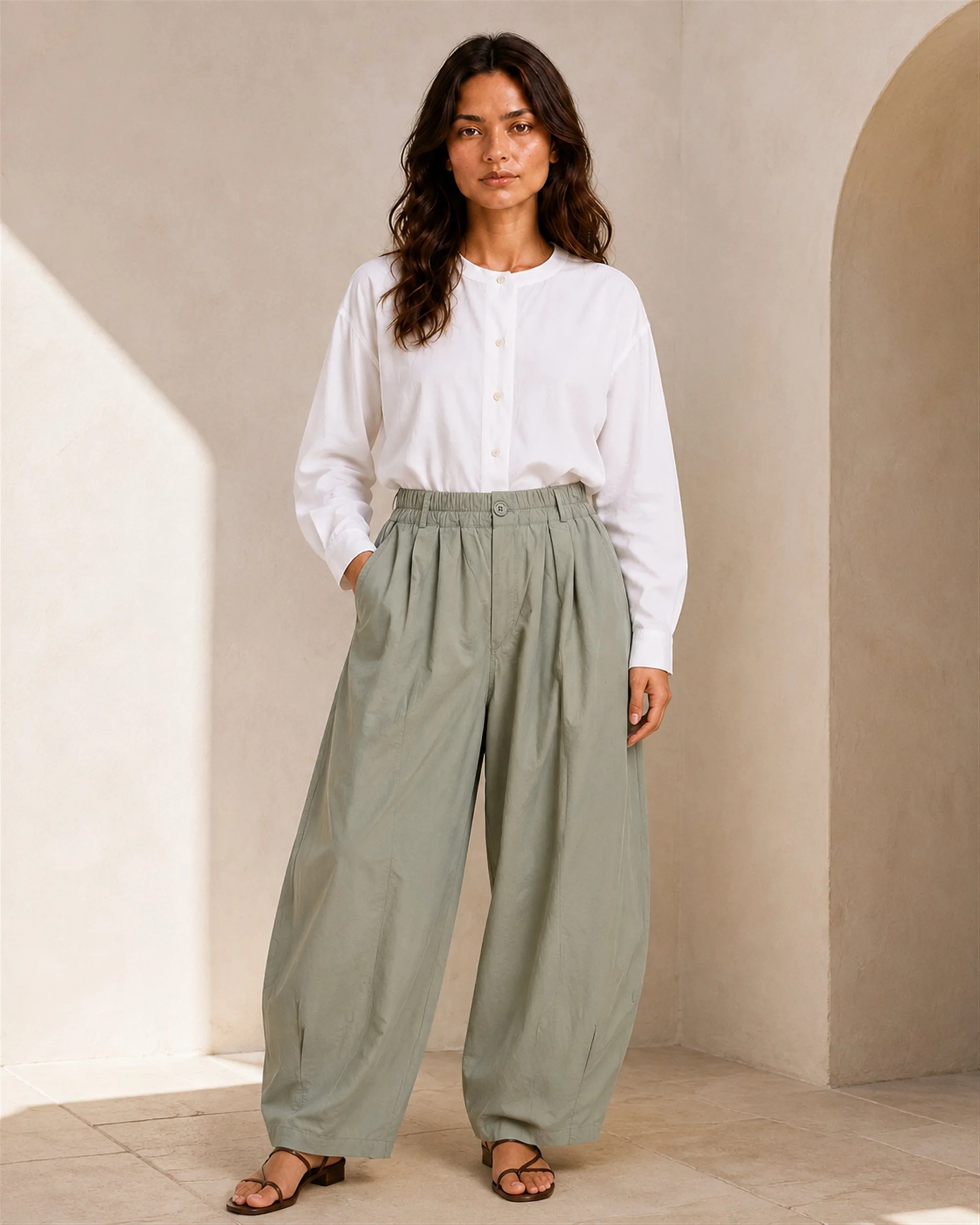 The Flax Studio khaki Button Front Crepe Pant styled with a white blouse, showing its gathered waist and relaxed barrel-leg silhouette.