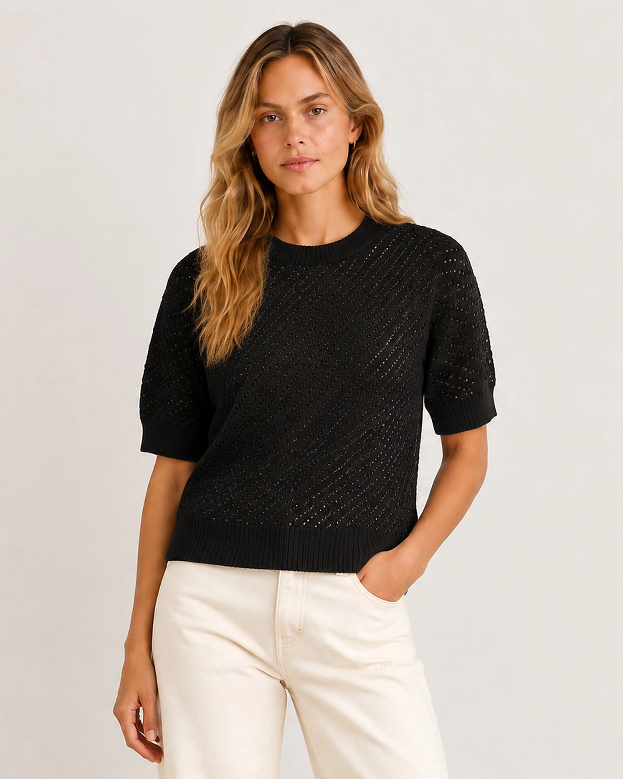 The Flax Studio Mulberry Silk-Cotton Pointelle Knit in black, showing the alternative colour worn with light trousers.
