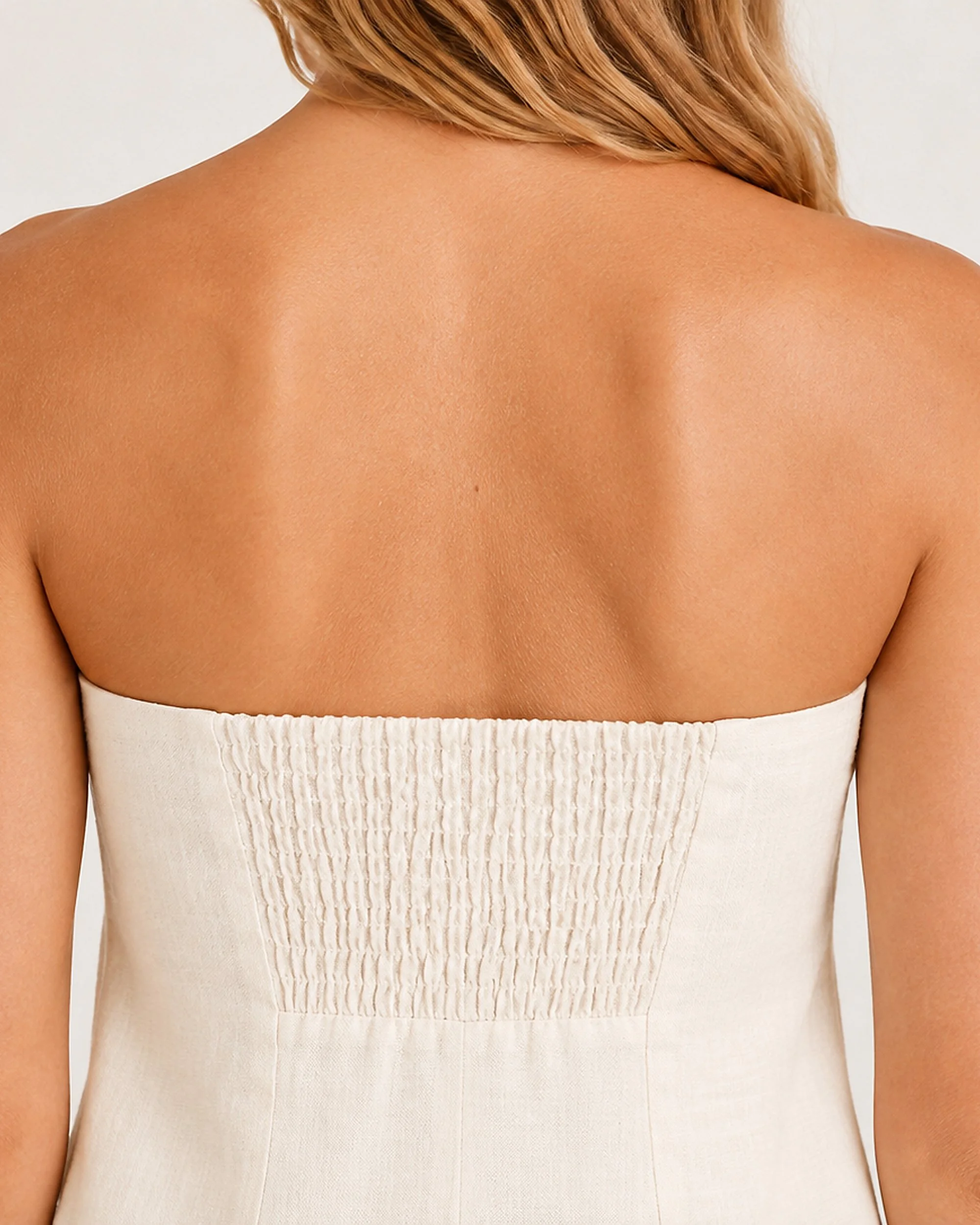Close-up of the centred shirred back panel on The Flax Studio Sand Strapless Linen Dress.