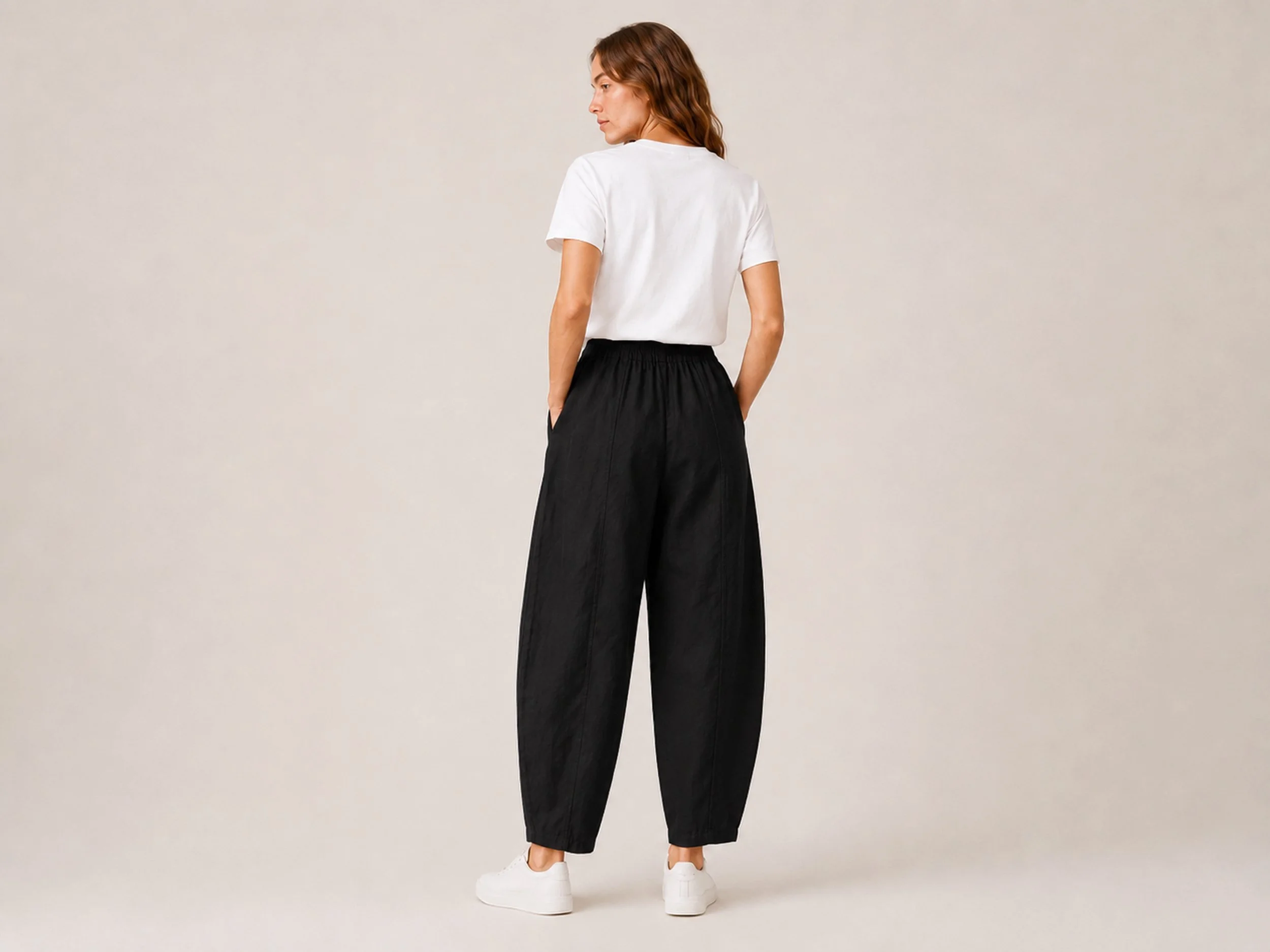 Back view of The Flax Studio black Sculpted Cotton Pant, showing the centre seams and tapered legs.