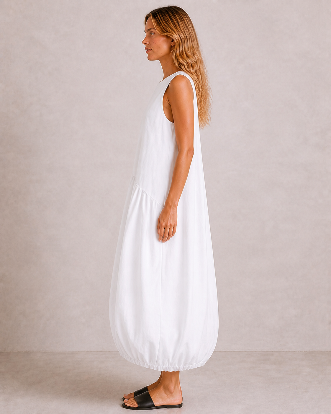 Side view of The Flax Studio white Arc Dress, showing its voluminous silhouette and gathered hem.