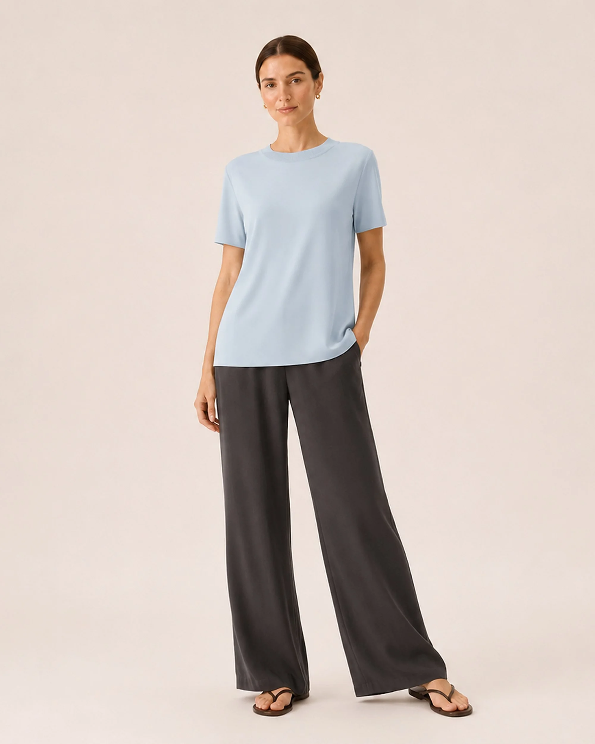 The Flax Studio blue Silk Crew Neck Top styled with dark trousers, front view.