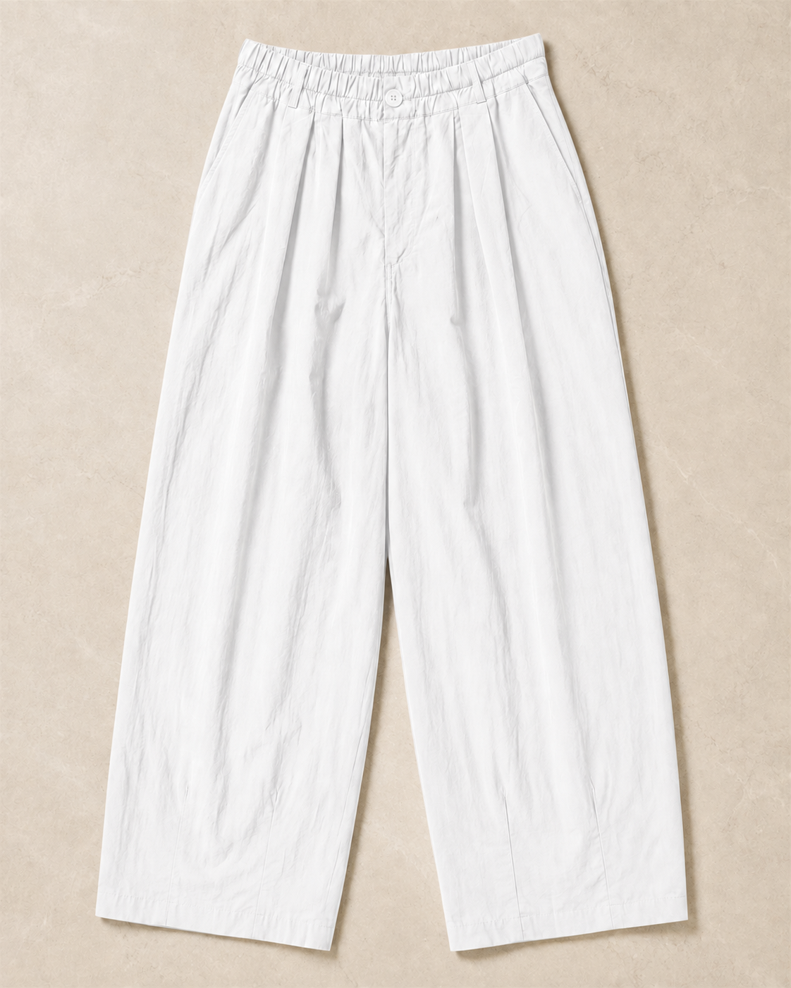 The Flax Studio white Button Front Crepe Pant laid flat, showing the gathered waistband and curved leg shape.