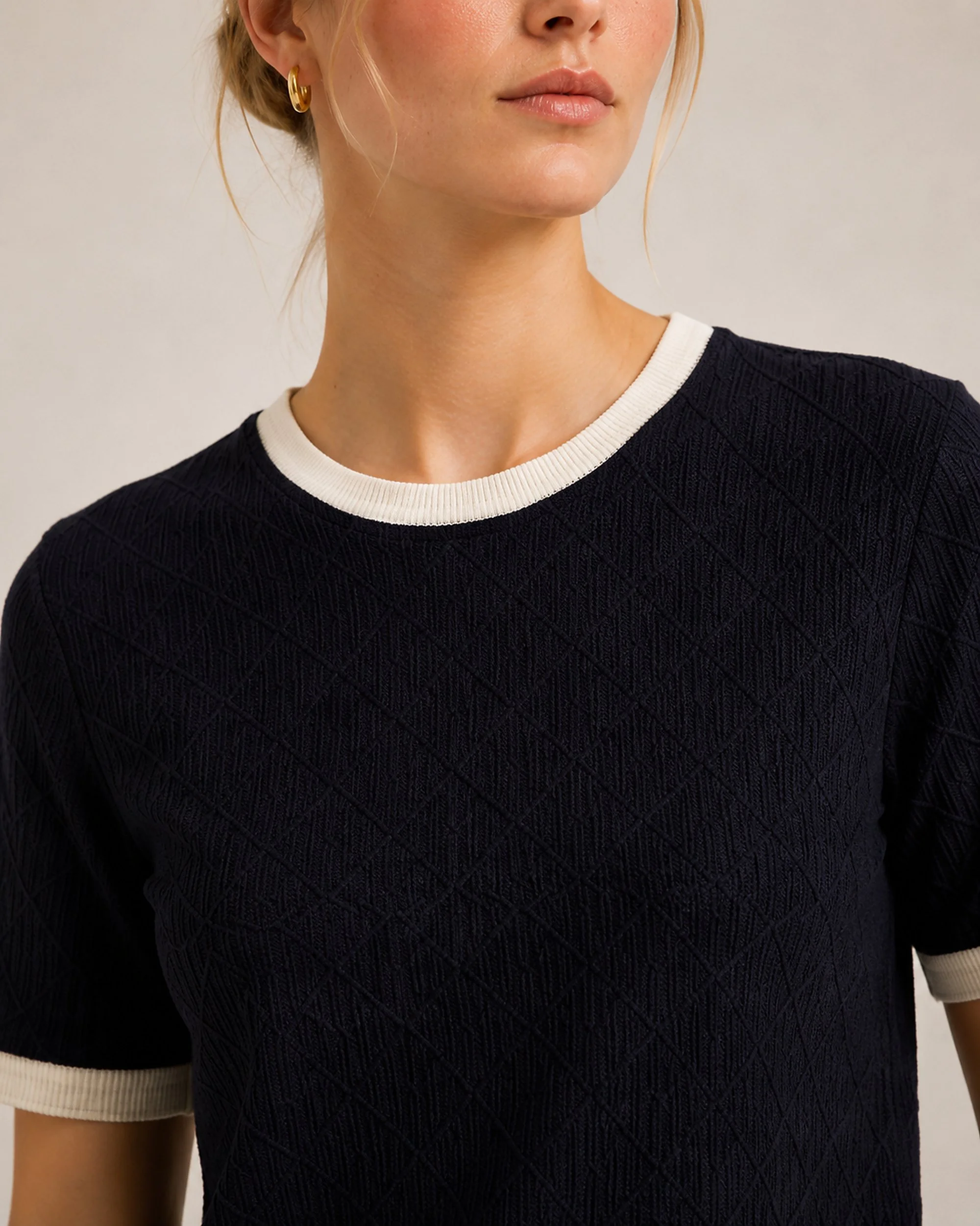 Close-up of the cream crew-neck trim and navy geometric knit on The Flax Studio silk-cotton T-shirt.