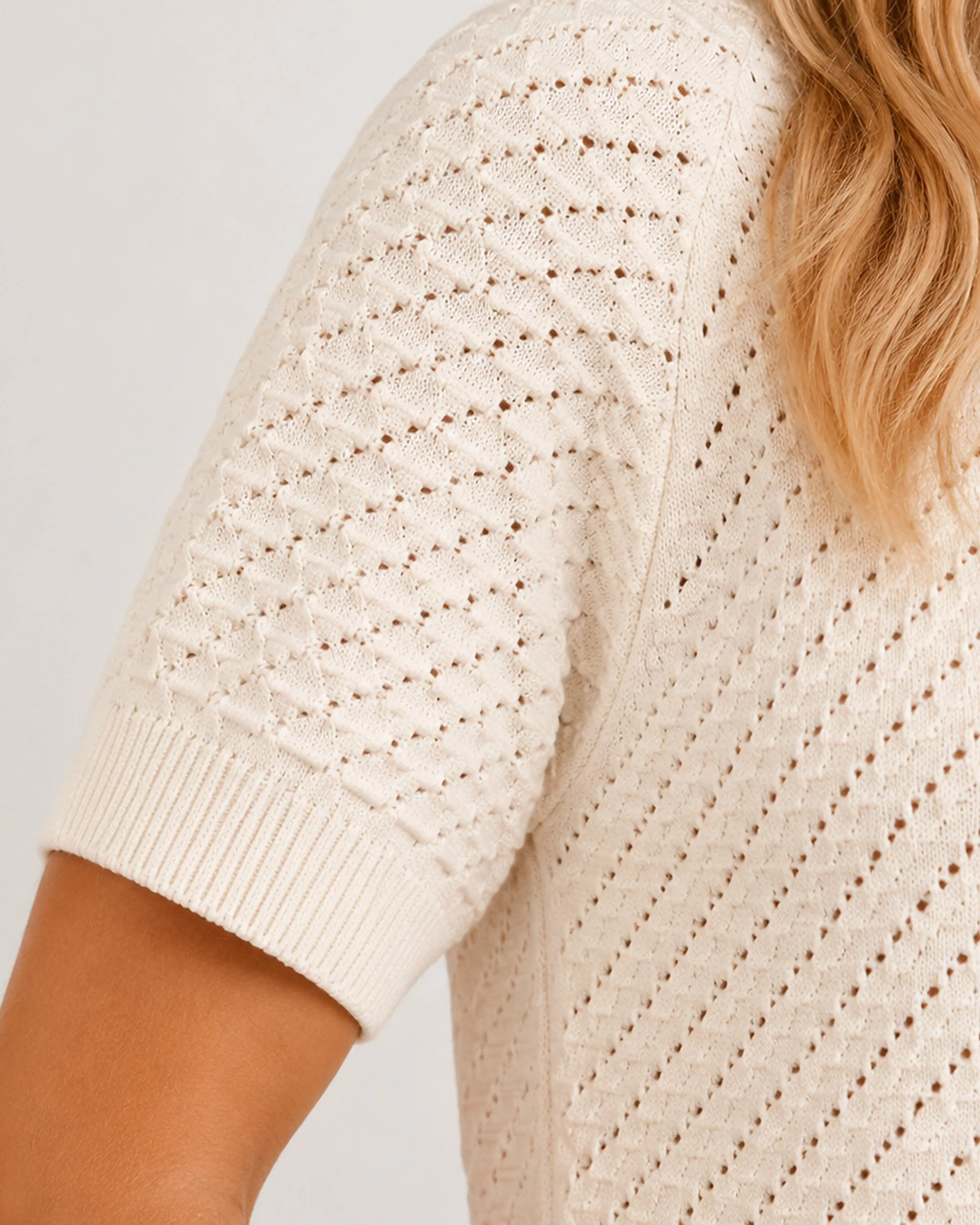 Sleeve detail of The Flax Studio cream Mulberry Silk-Cotton Pointelle Knit, showing the pointelle pattern and ribbed cuff.