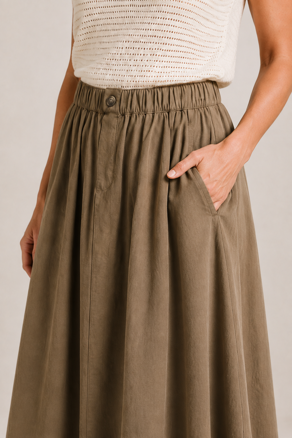 Close-up of The Flax Studio khaki Button Front Skirt, showing the elasticated waistband, button detail and side pocket.