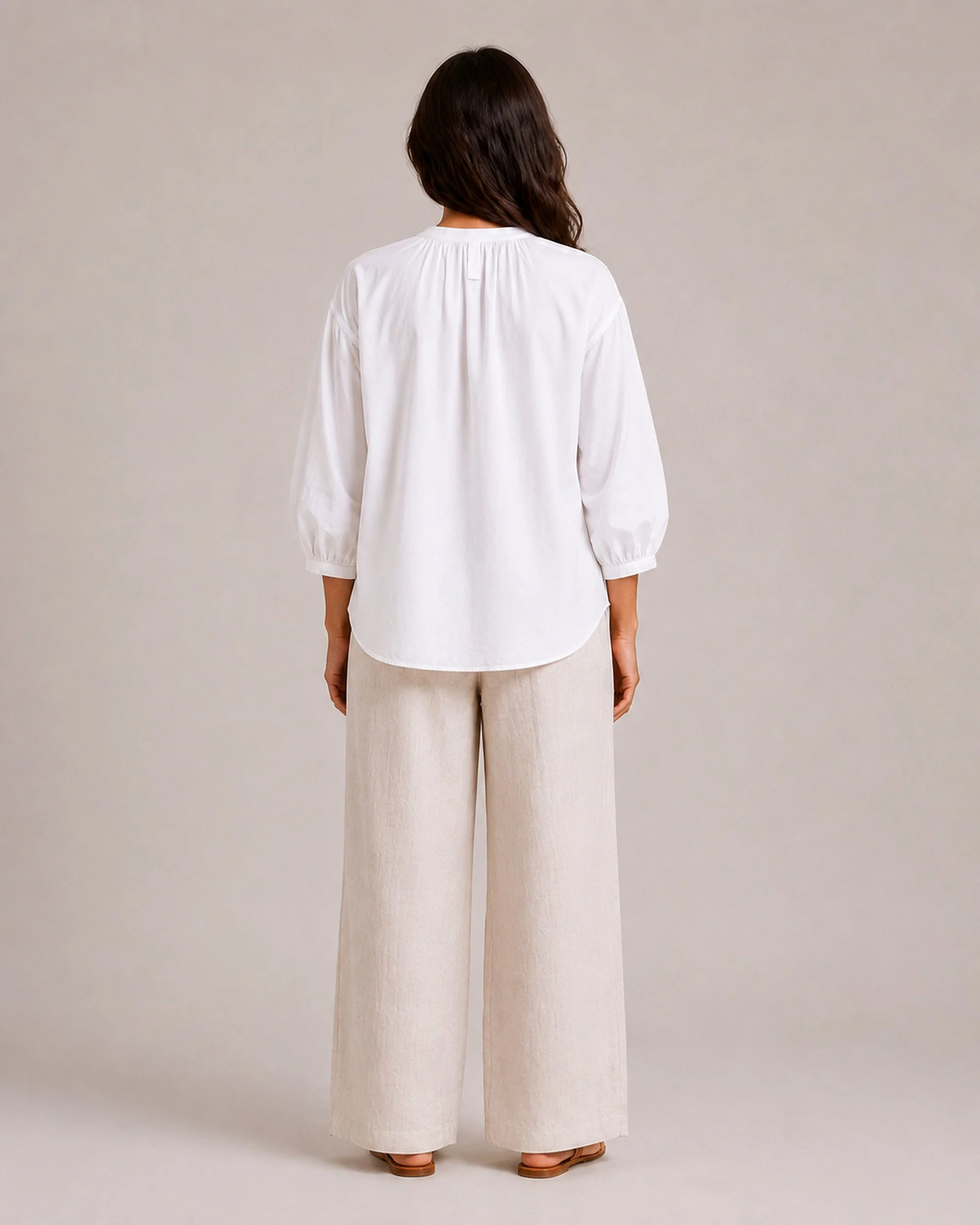 Back view of The Flax Studio white Voluminous Cotton Top, showing the shoulder gathering and curved hem.
