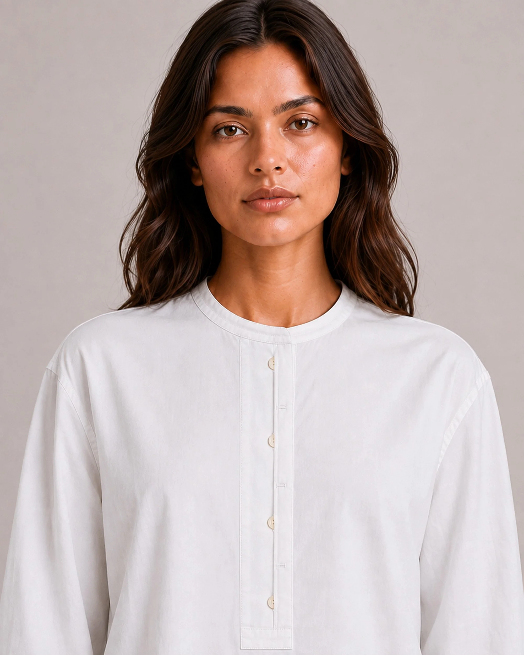 Close-up of The Flax Studio white Voluminous Cotton Top, showing its round neckline and button placket.