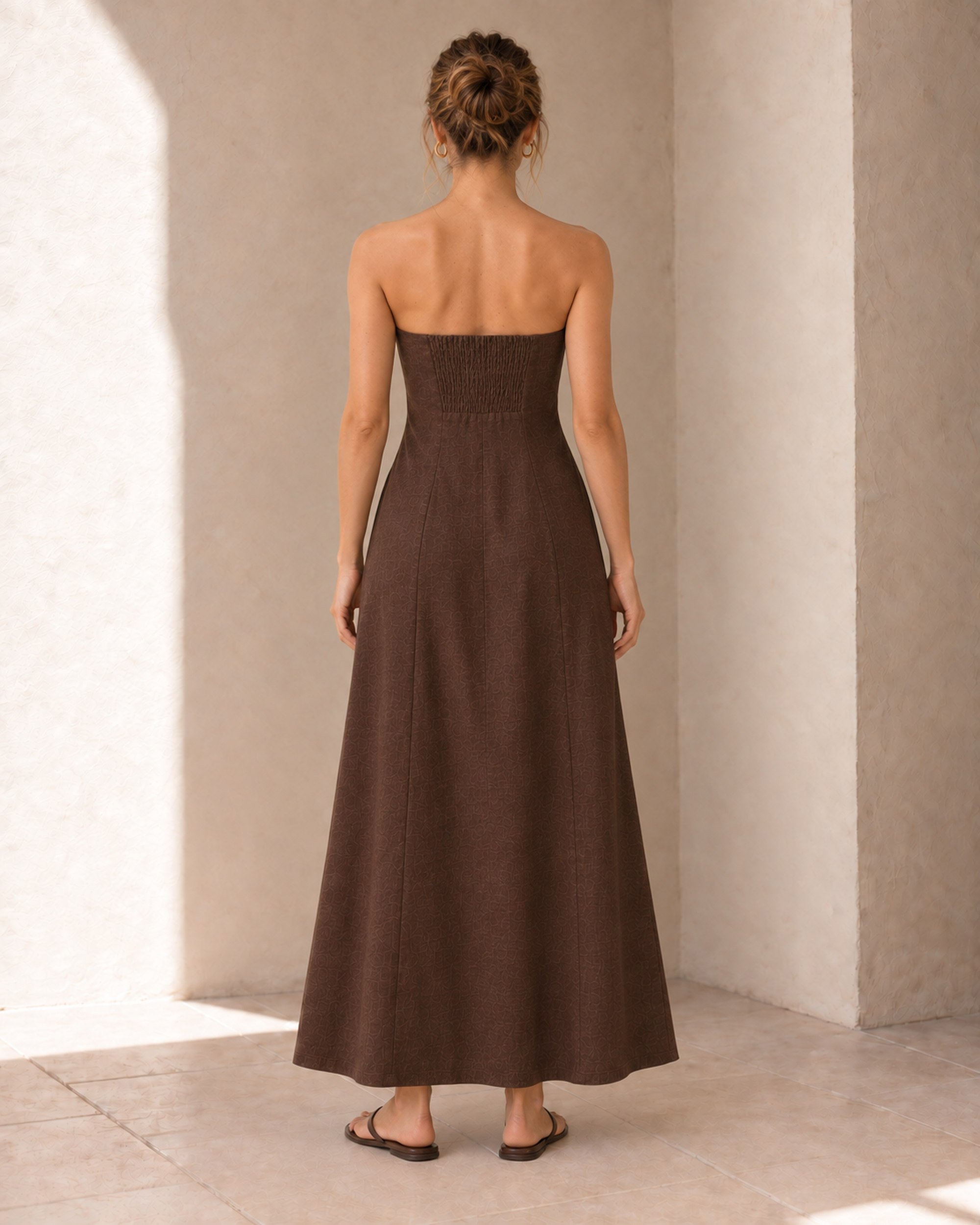 Back view of the Chocolate Strapless Linen Dress, showing the centred shirred panel and full-length silhouette.