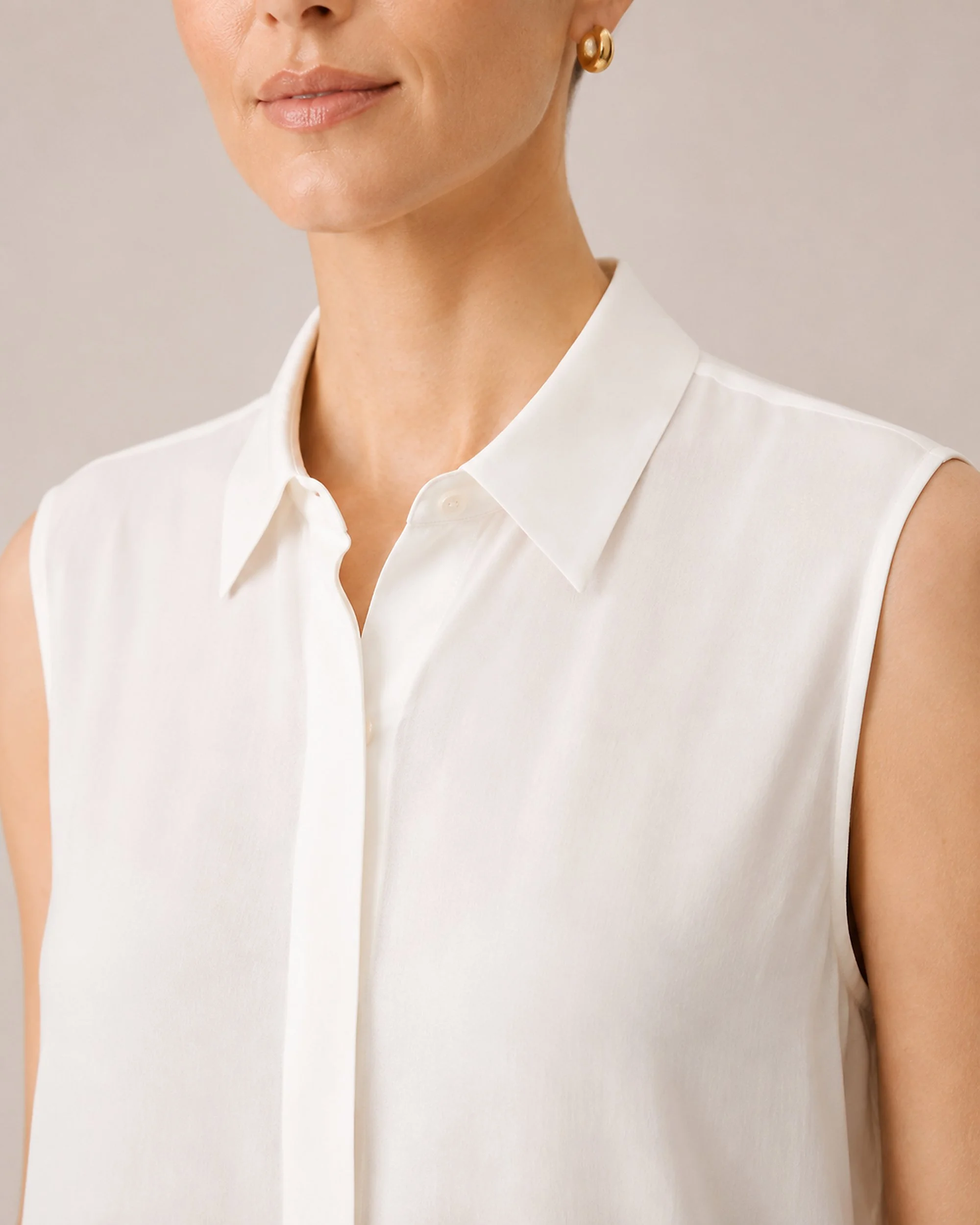 Close-up of the pointed collar and concealed button placket on The Flax Studio white silk sleeveless blouse.