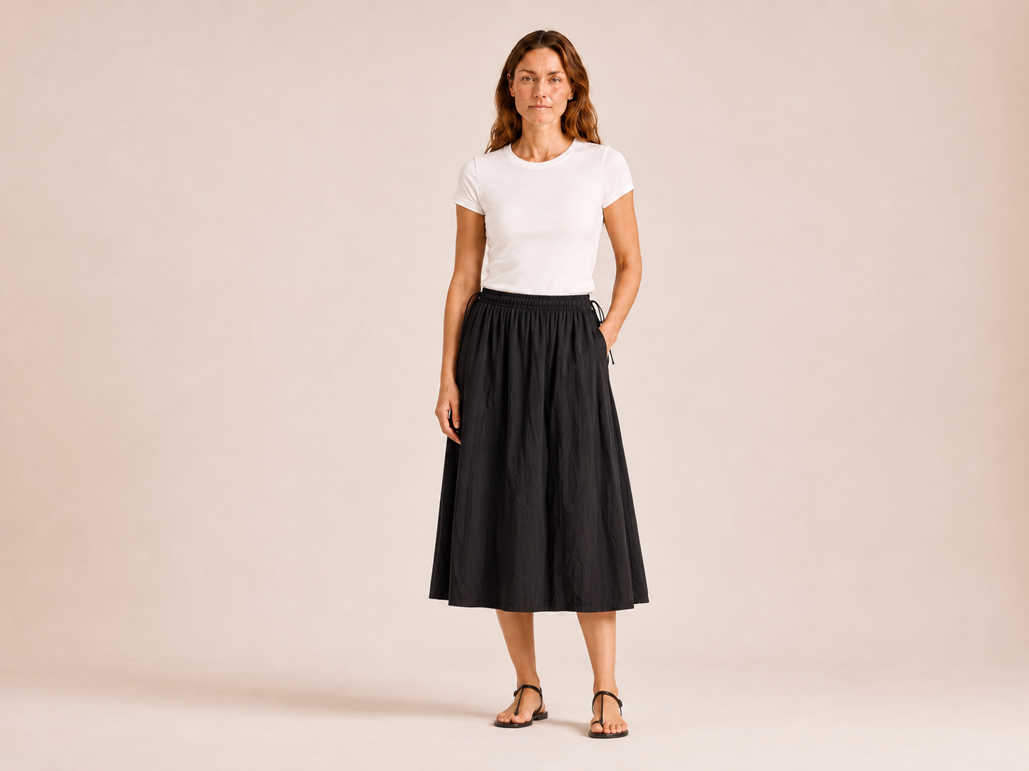 Front view of The Flax Studio black Cotton Tie Skirt with a softly gathered waist and midi hem.
