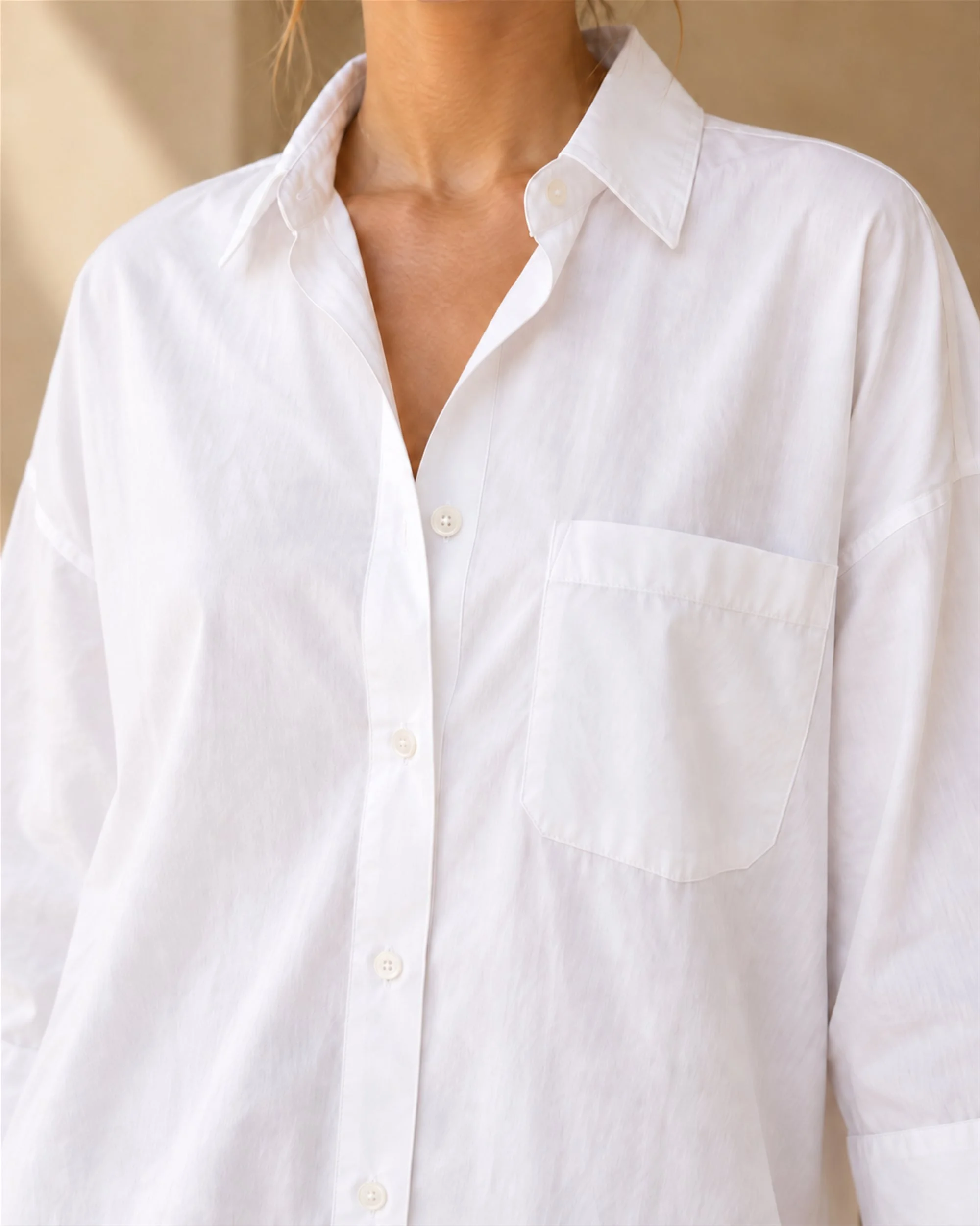 Close-up of the white Oversized Cotton Shirt, showing the collar, button front and chest pocket.