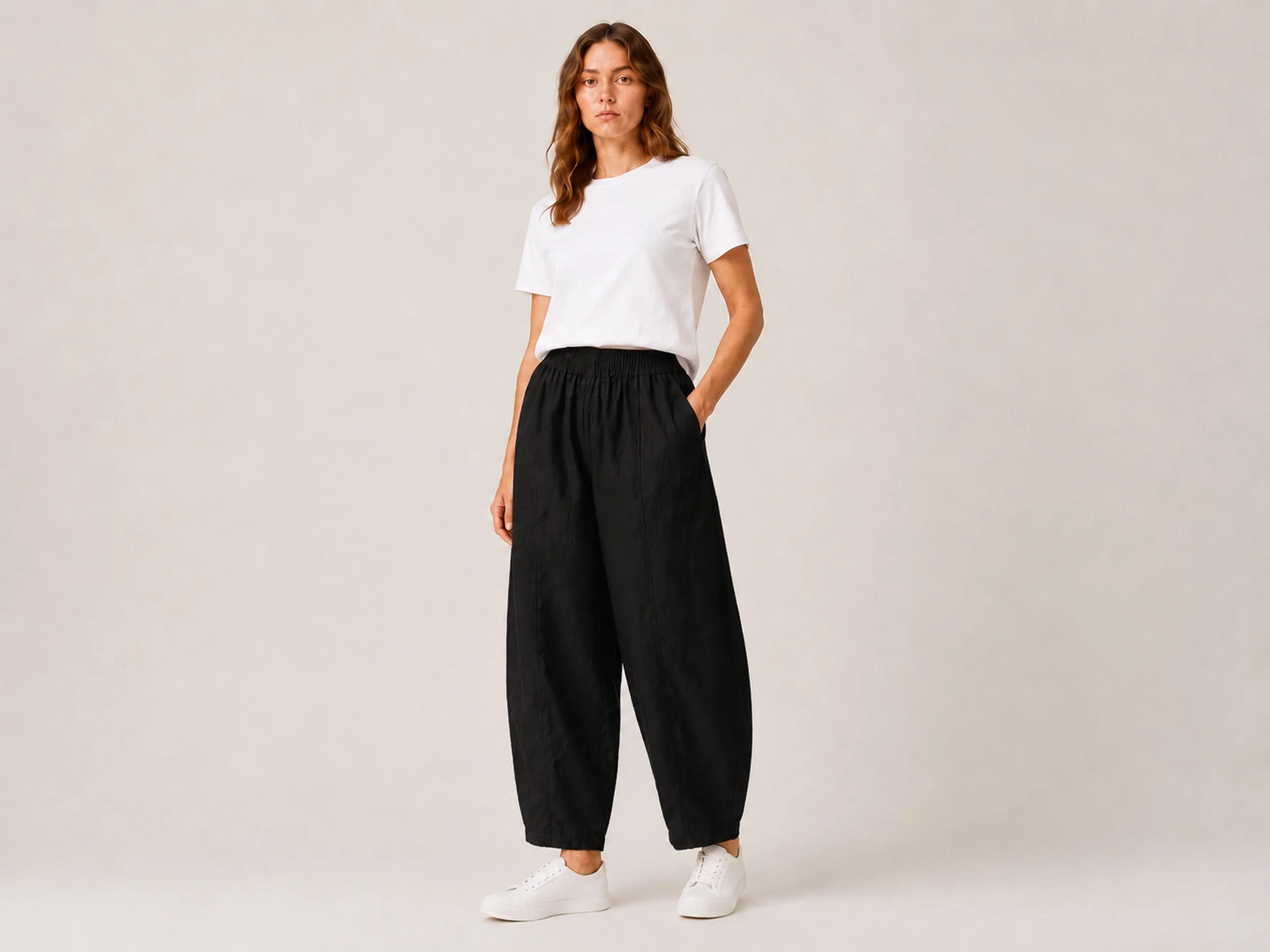 Front view of The Flax Studio black Sculpted Cotton Pant, showing its voluminous curved legs and tapered hems.