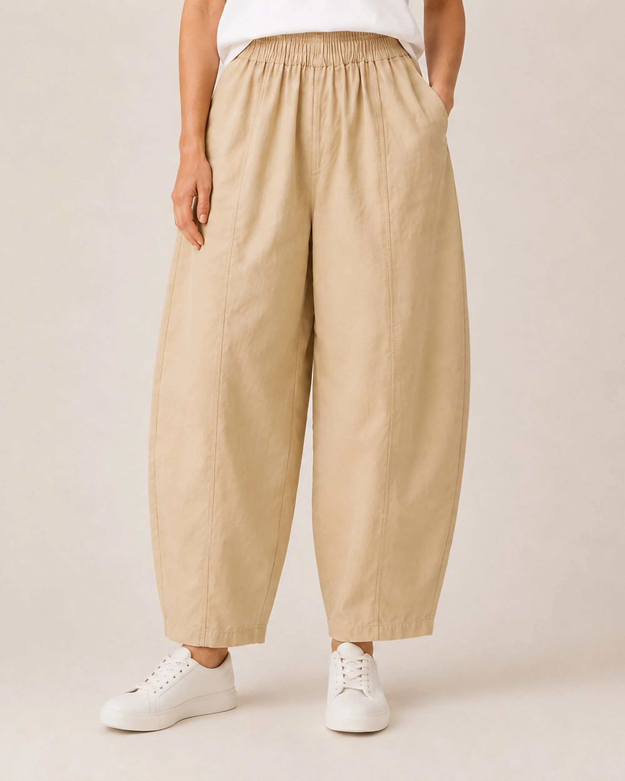 Front detail of The Flax Studio tan Sculpted Cotton Pant, showing the curved legs, centre seams and tapered hems.