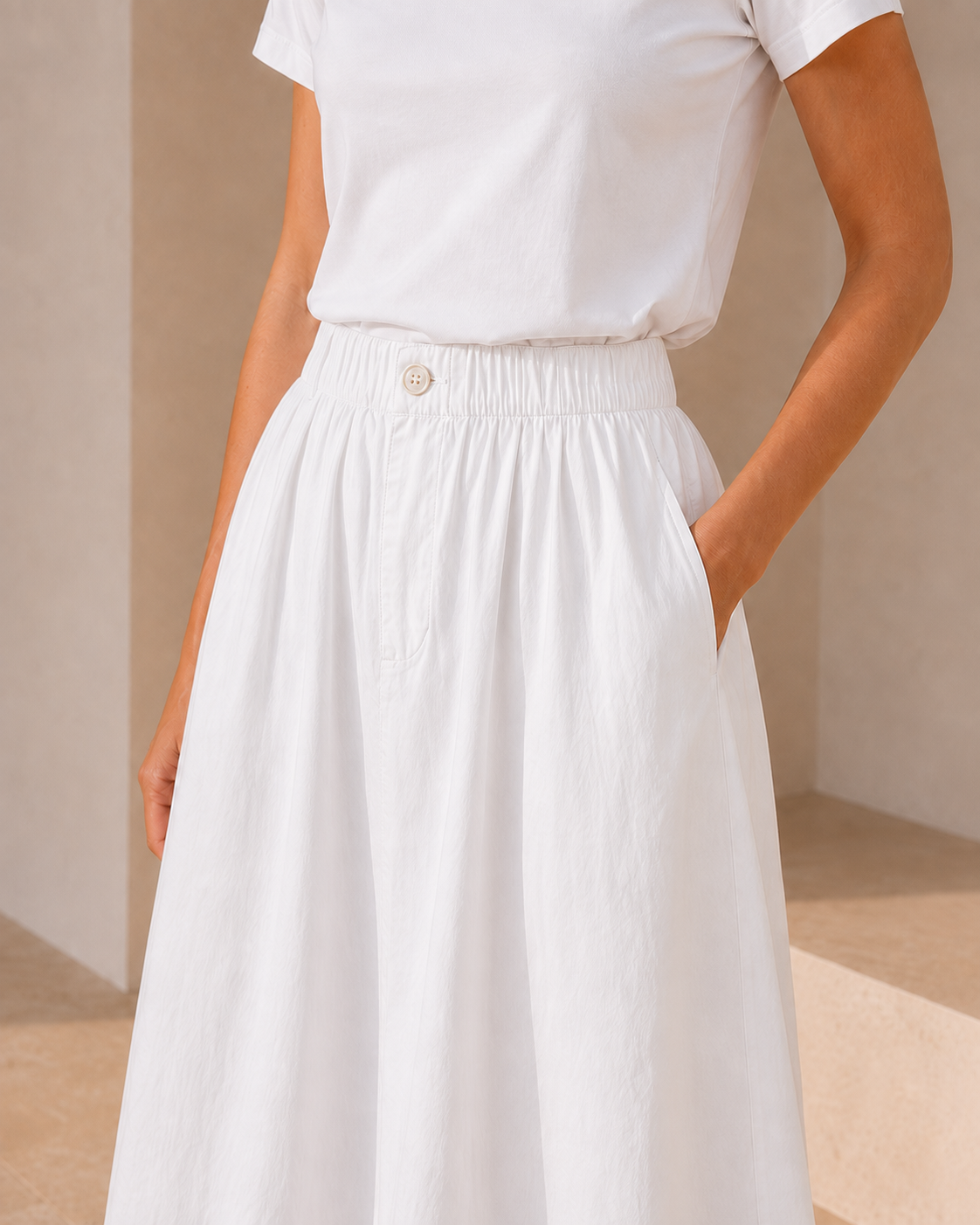 Close-up of The Flax Studio white Button Front Skirt, showing the elasticated waistband, button detail and side pocket.