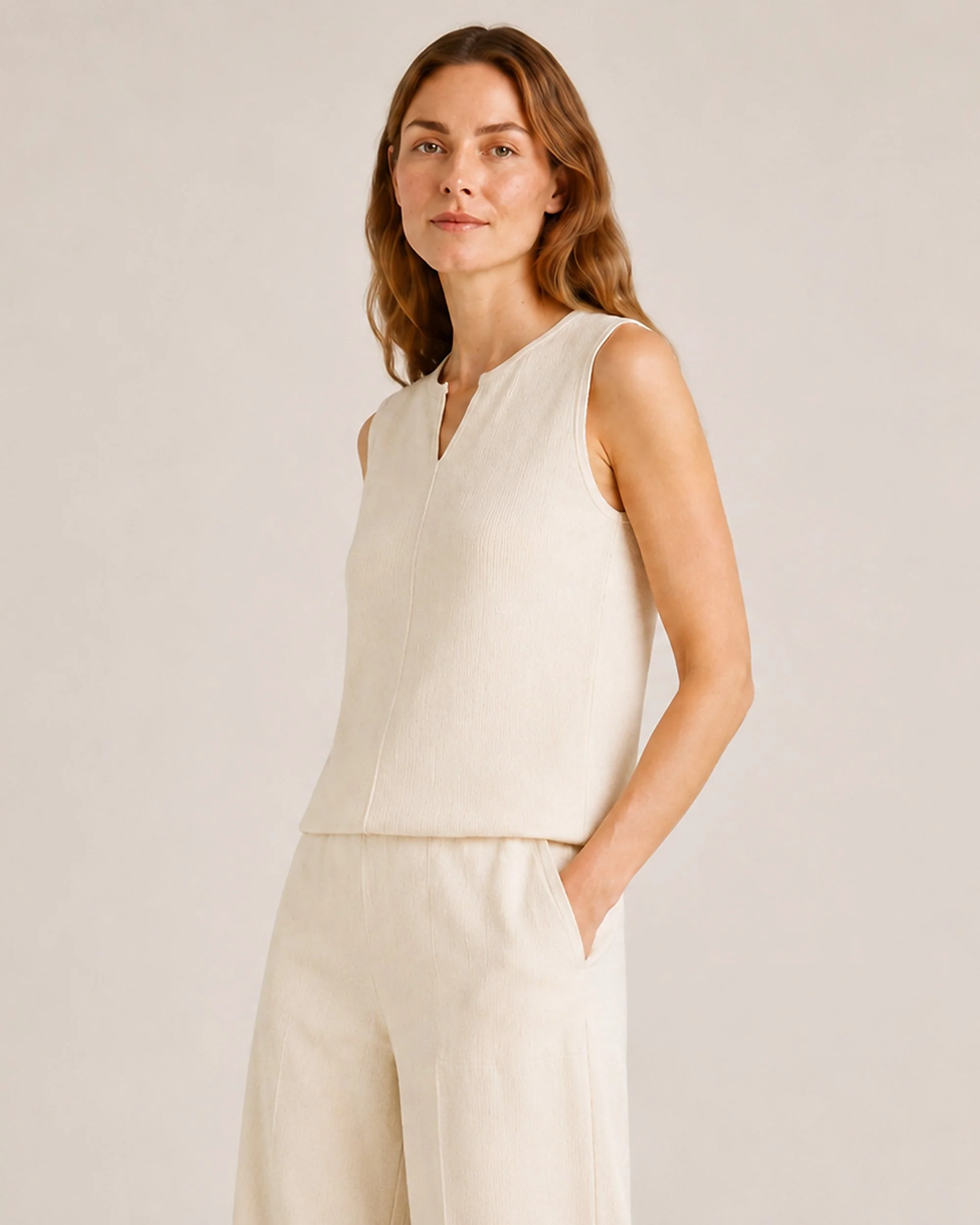 Angled view of The Flax Studio cream Fine Rib Knit Set, showing the relaxed sleeveless top and matching pants.