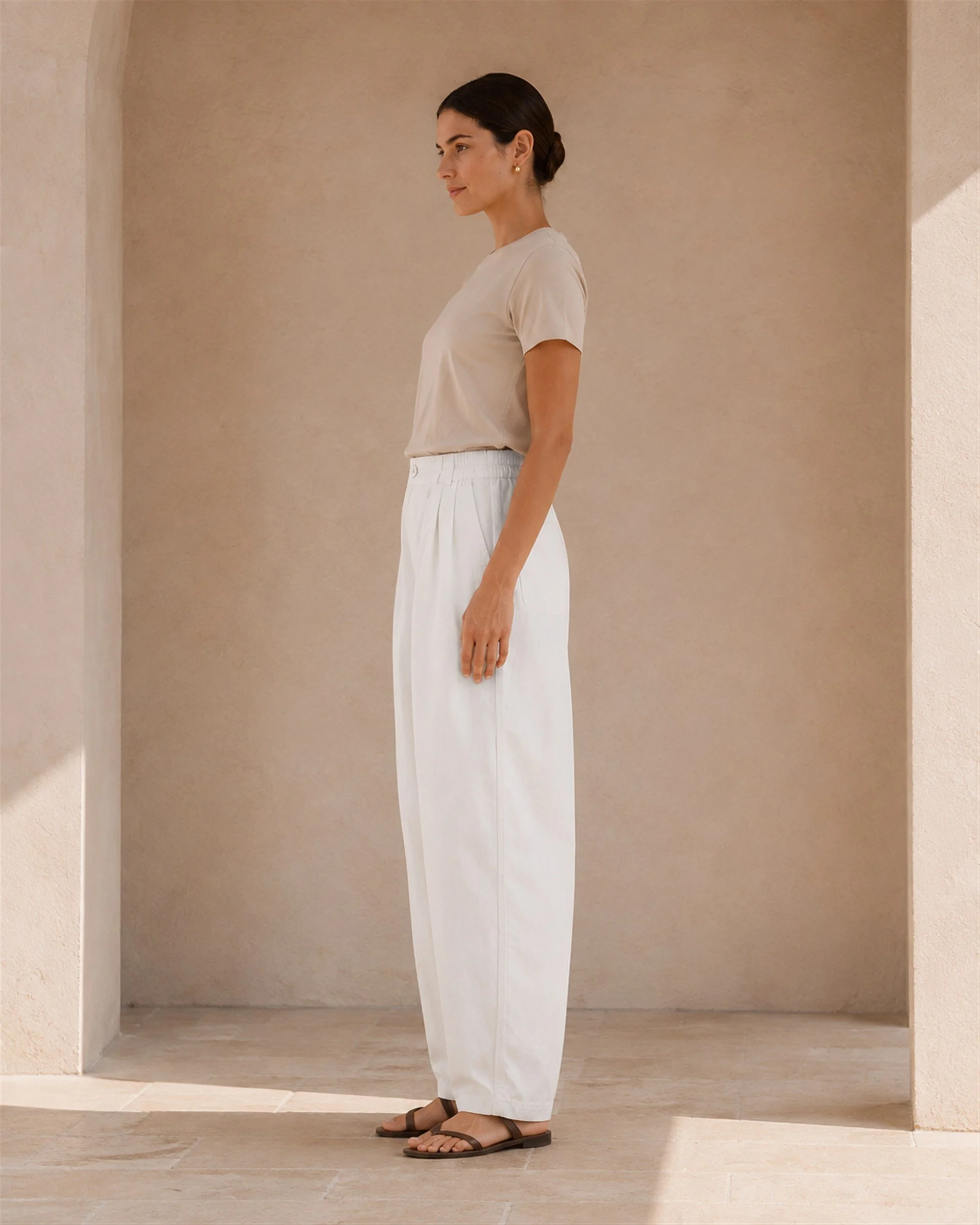 Side view of The Flax Studio white Button Front Crepe Pant styled with a beige T-shirt.