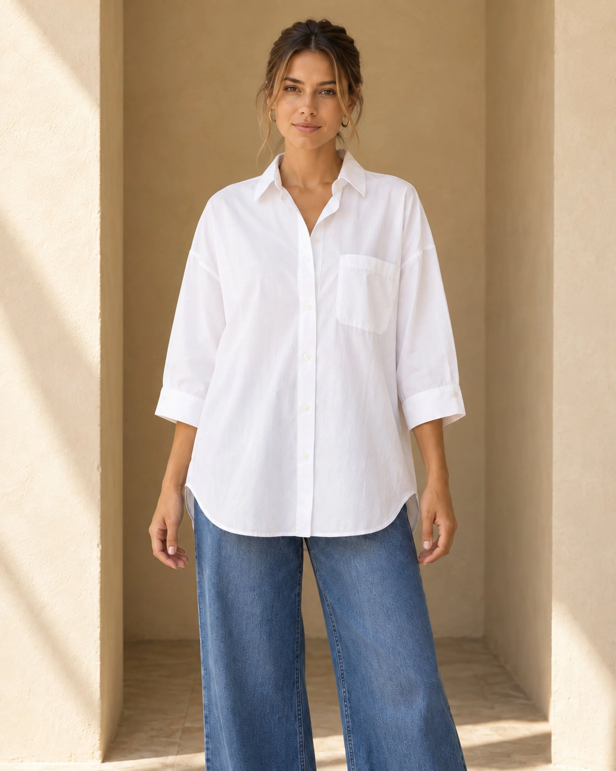 Front view of the white Oversized Cotton Shirt, showing its button front, chest pocket and curved hem.