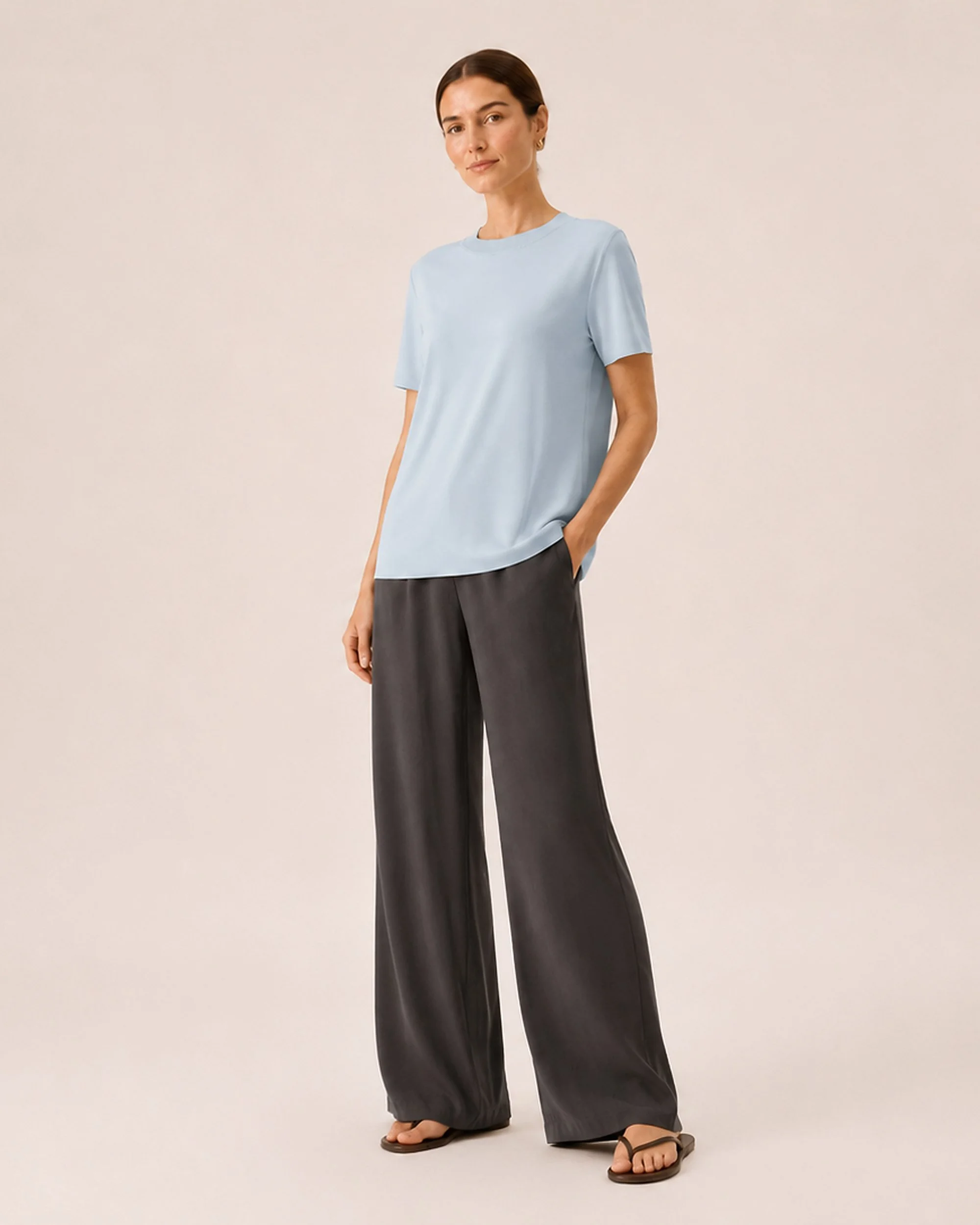 The Flax Studio blue Silk Crew Neck Top in an angled front pose, styled with dark trousers.