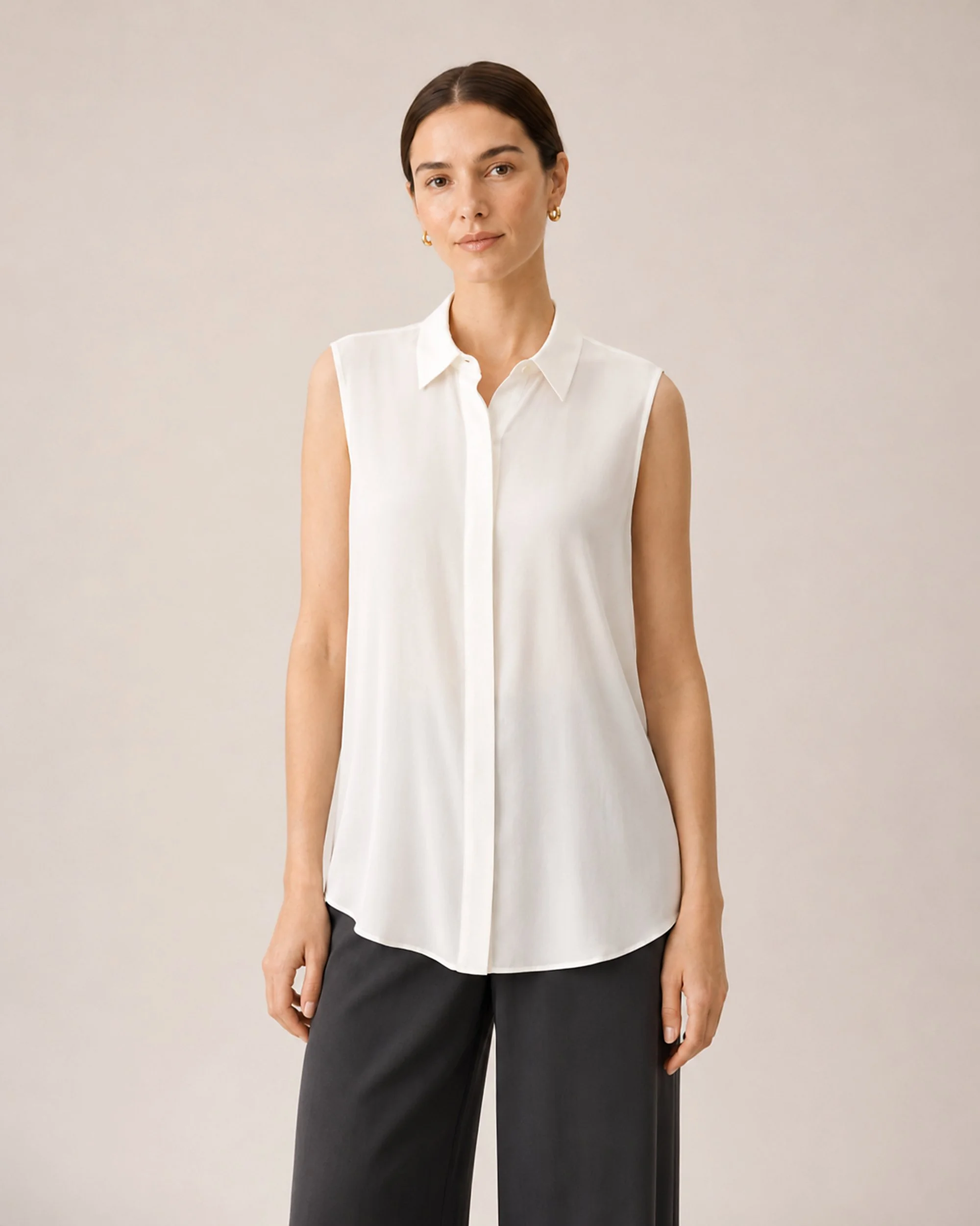 Front view of The Flax Studio white Mulberry Silk Sleeveless Blouse worn loose with dark trousers.