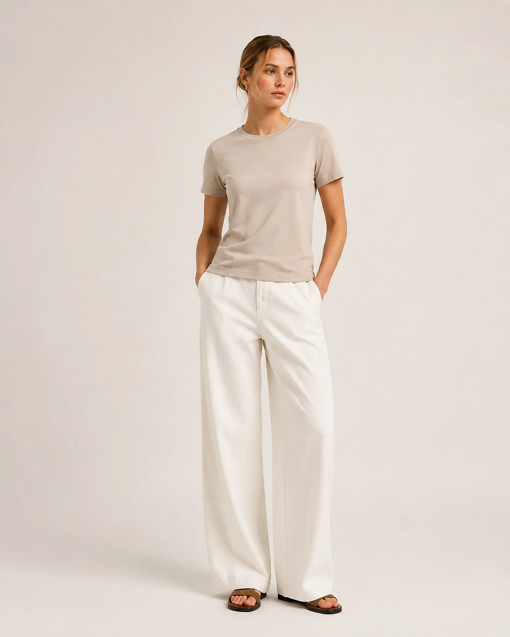 The Flax Studio mercerised cotton T-shirt in sand, showing the alternative colour styled with white trousers.