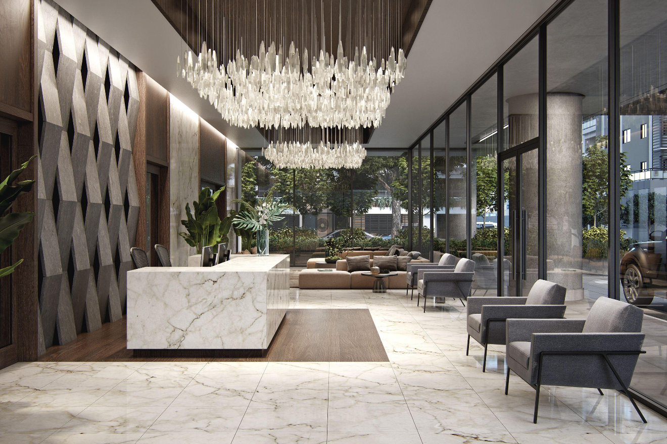 Modern hotel lobby with marble flooring, a white marble reception desk, large chandeliers, comfortable seating, and floor-to-ceiling glass windows overlooking trees and a city street.