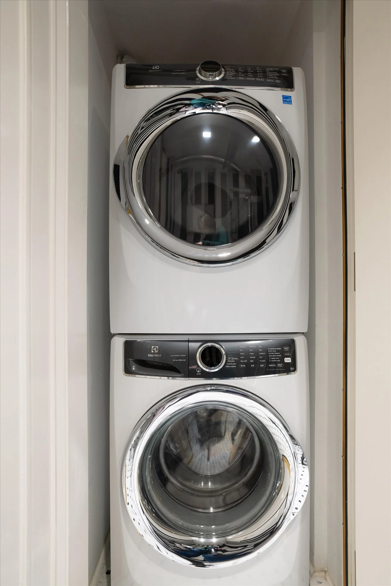 Stacked front-loading washing machines in a laundry area.