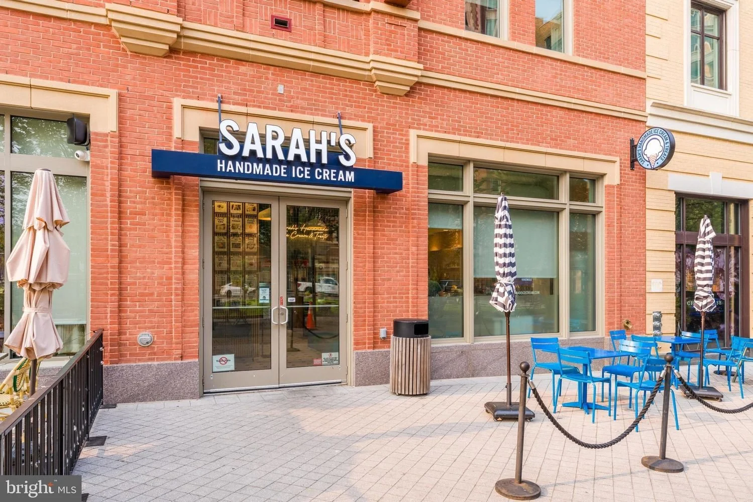 Exterior of Sarah's Handmade Ice Cream shop with outdoor seating, umbrellas, and a sign
