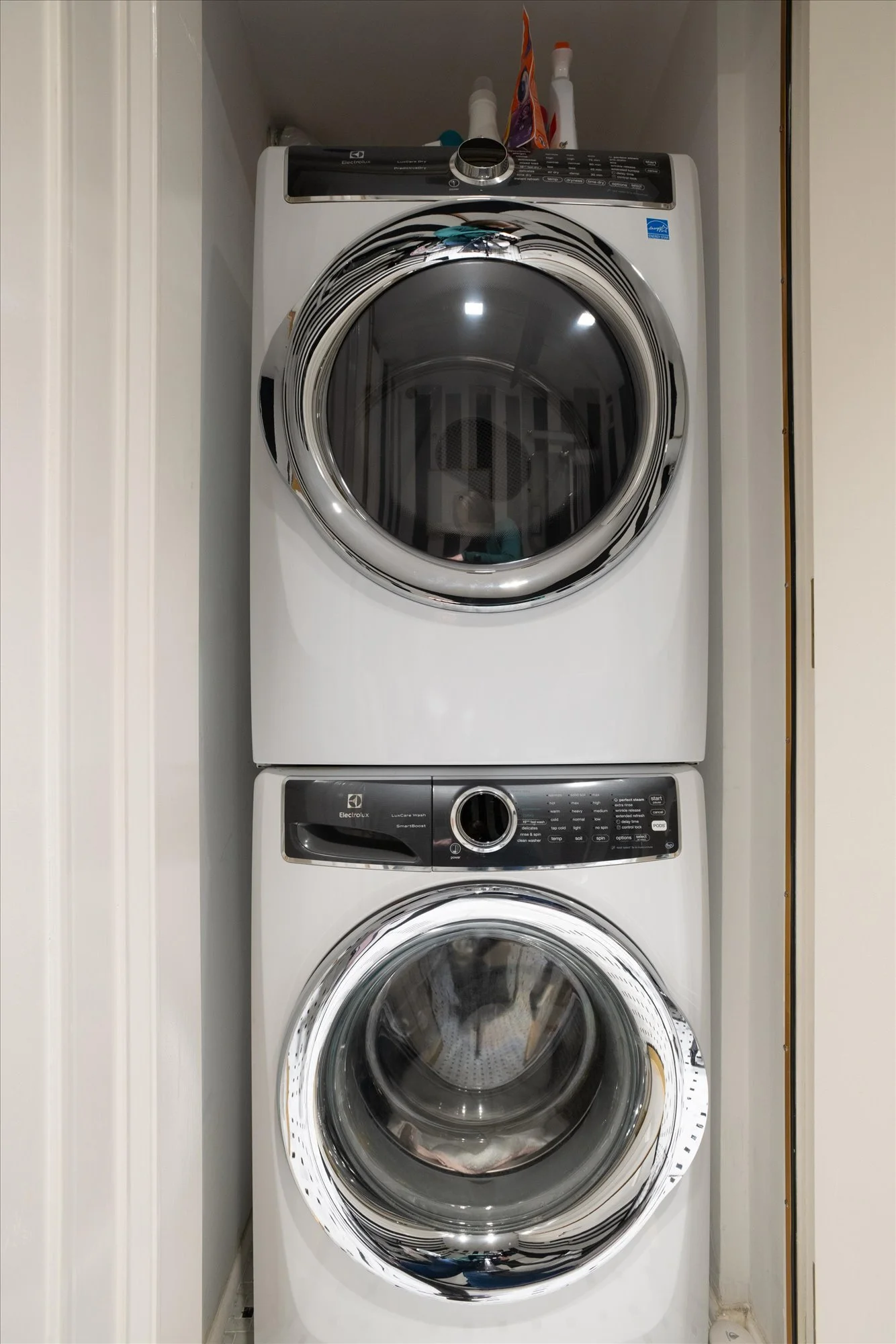 Stacked front-loading washer and dryer in a laundry closet.