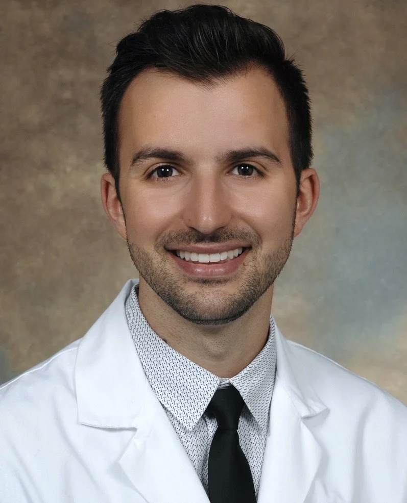 Michael, a CRNA and founder of Talmiro, smiling in a white coat.